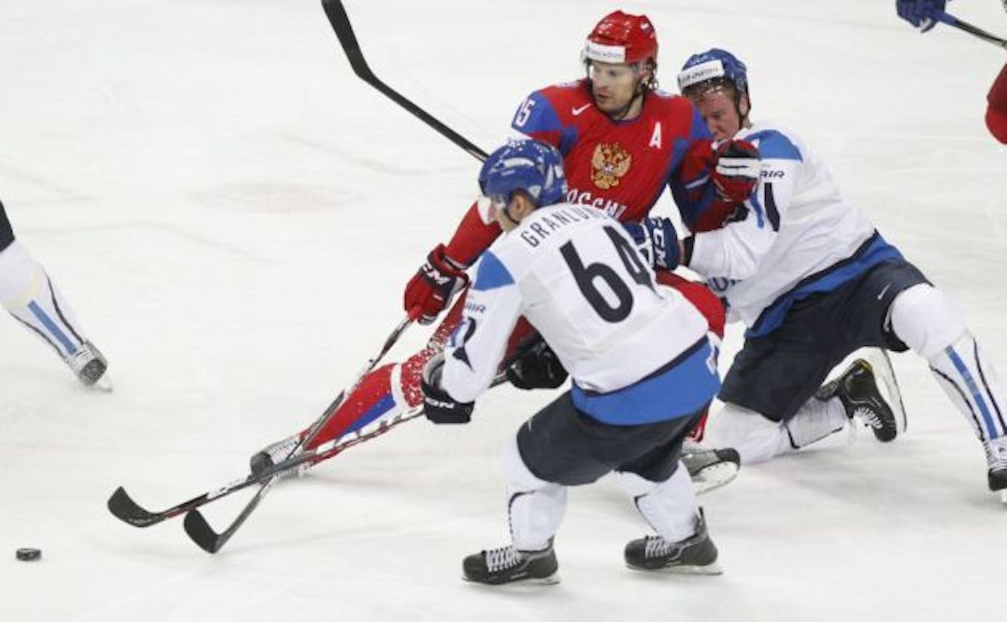 Russia's Alexander Svitov, center, fights for the puck with Finland's Mikael Granlund, left, and Finland's Ossi Vaananen during their IIHF Ice Hockey World Championships semifinal match at the Hartwall Arena in Helsinki, Finland, Saturday, May 19, 2012. (AP Photo/Dmitry Lovetsky)