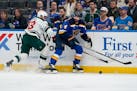 St. Louis Blues' Nick Leddy chases after a loose puck along the boards as the Wild's Sam Steel defends during the first period Tuesday