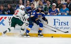 St. Louis Blues' Nick Leddy chases after a loose puck along the boards as the Wild's Sam Steel defends during the first period Tuesday