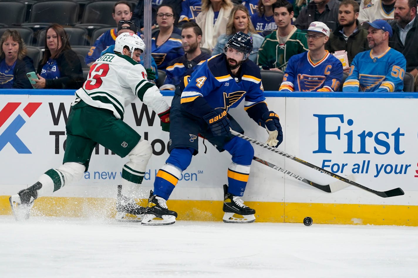 St. Louis Blues' Nick Leddy chases after a loose puck along the boards as the Wild's Sam Steel defends during the first period Tuesday