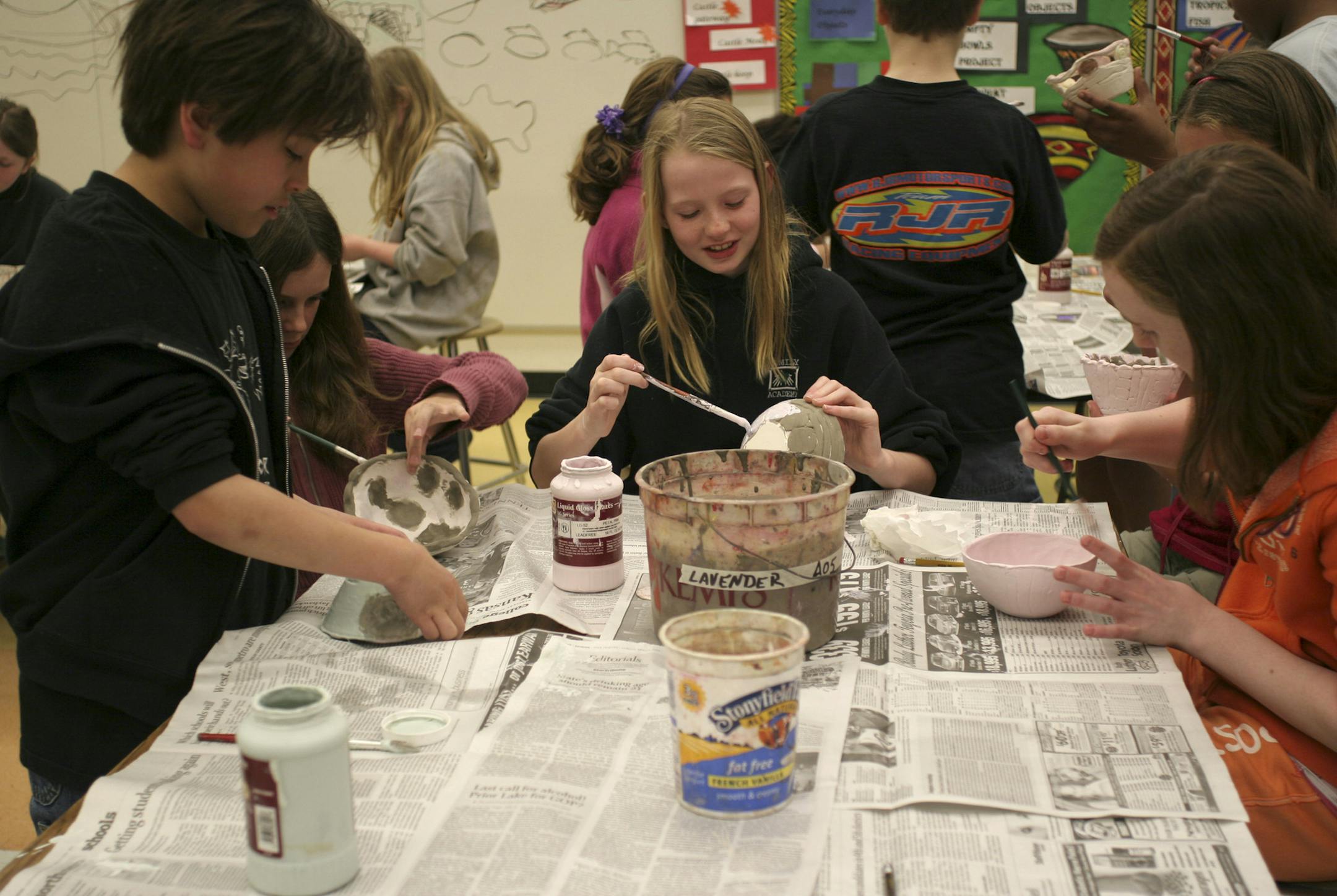 PHOTO BY MARIA BACA. Peter Goggin, Kailey Leksen, Natalie Linders, Mackenzie Wild and Hannah Schultz chatted as they§brushed glaze onto the bowls they'd made. Mounds View district§students will host a soup-and-bread Empty Bowls dinner§April 28 at Irondale High School; proceeds from the soup and§bowl sales will go to benefit Feed My Starving Children. All are 11 years old.