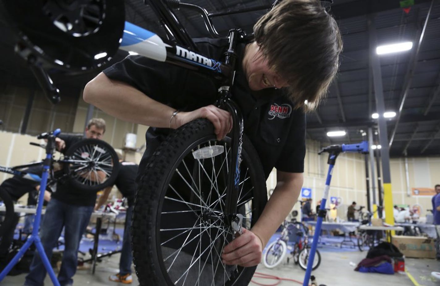 Vanessa Schroeder, of Penn Cycle, tightened the wheels on a bike for Free Bikes 4 Kidz in Hopkins, Min., Wednesday November 28, 2012. This was Battle of the Bike Shops in which teams of mechanics representing Twin Cities bike stores scrambled to see which one can assemble the most bikes.