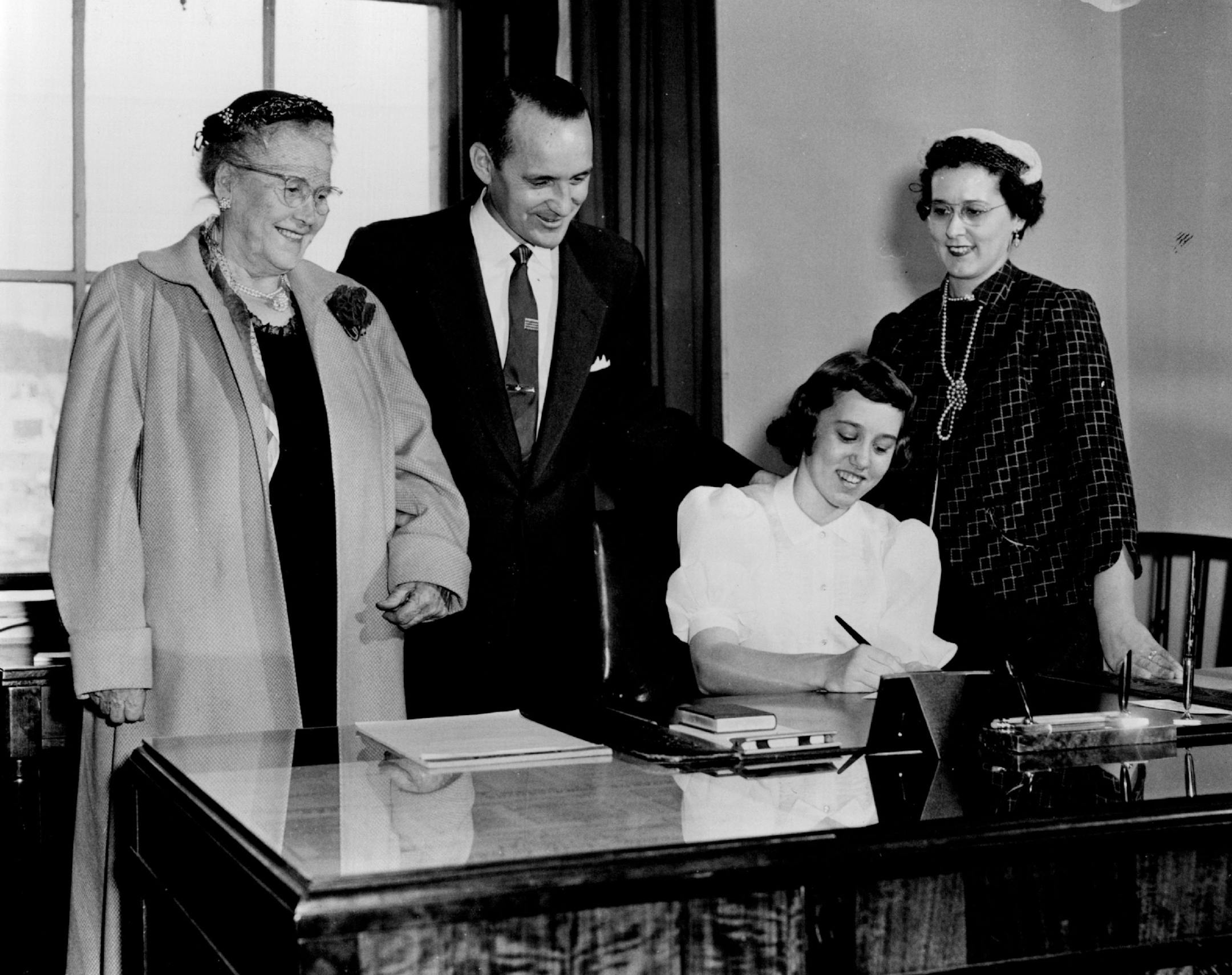 January 3, 1955 Priscilla Lord, 12, tries out her father's new desk as Mrs. Rachel Lord, Ironton, mother of Miles, Miles, and Mrs. Miles Lord watch. January 7, 1955 Powell Krueger, Minneapolis Star Tribune