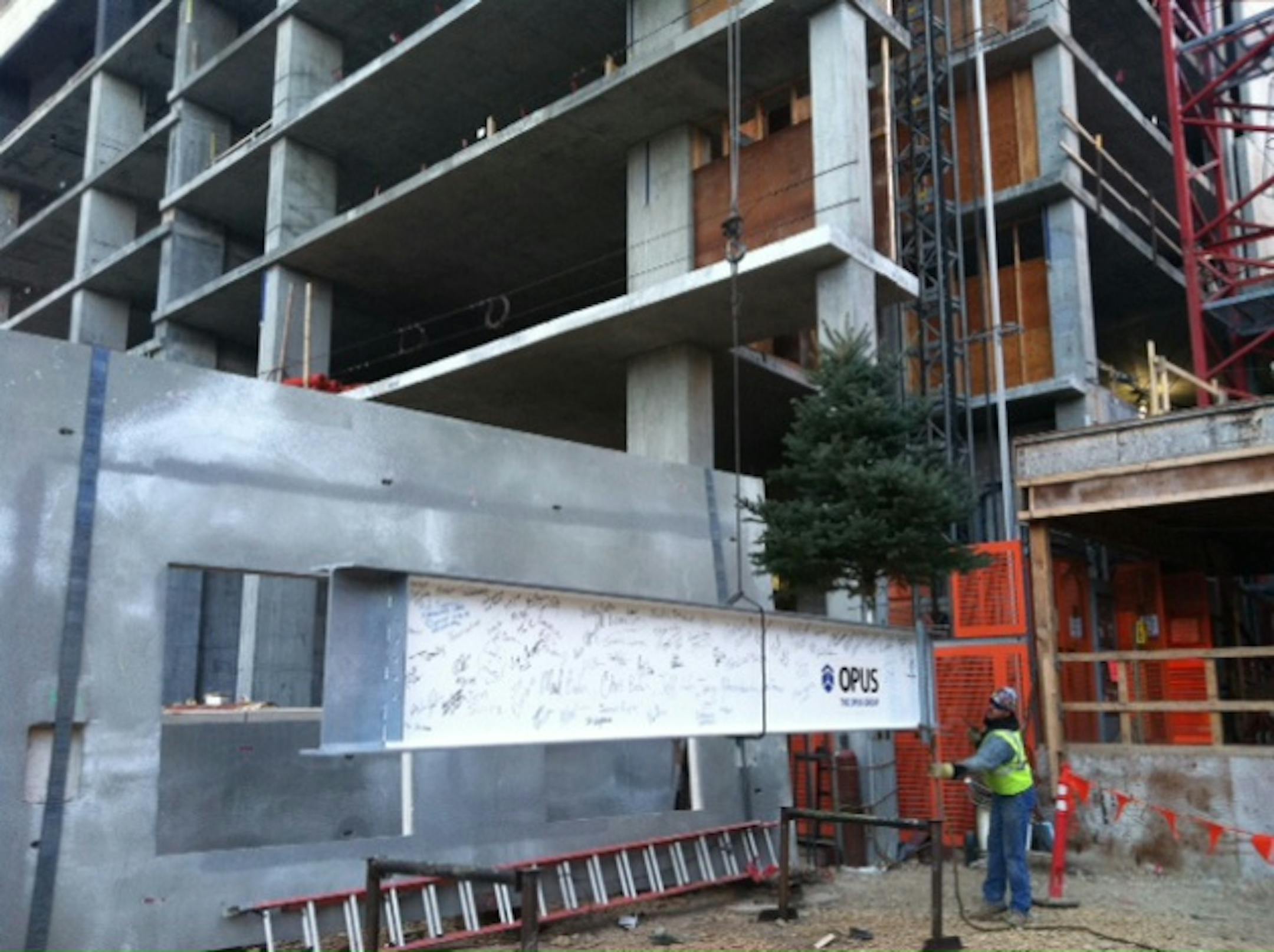 Ceremonial beam is hoisted to the top of Nic on Fifth