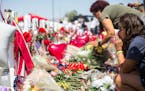 People on Wednesday, Aug. 7, 2019, visit the makeshift memorial for the victims of the mass shooting on Saturday at a Walmart store in El Paso, Texas.