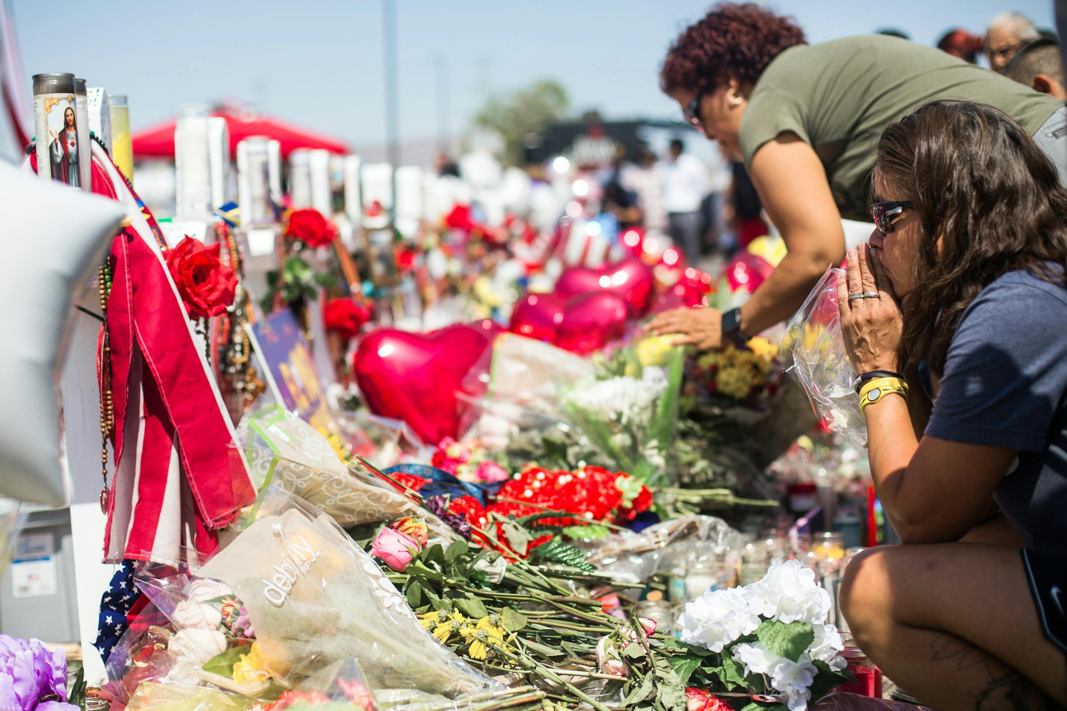 People on Wednesday, Aug. 7, 2019, visit the makeshift memorial for the victims of the mass shooting on Saturday at a Walmart store in El Paso, Texas. President Donald Trump is visiting El Paso and Dayton, Ohio, on Wednesday in an attempt to deliver a message of national unity and healing to two cities scarred by mass shootings over the weekend and where many grieving residents hold him responsible for inflaming the country’s racial divisions. (Celia Talbot Tobin/The New York Times)