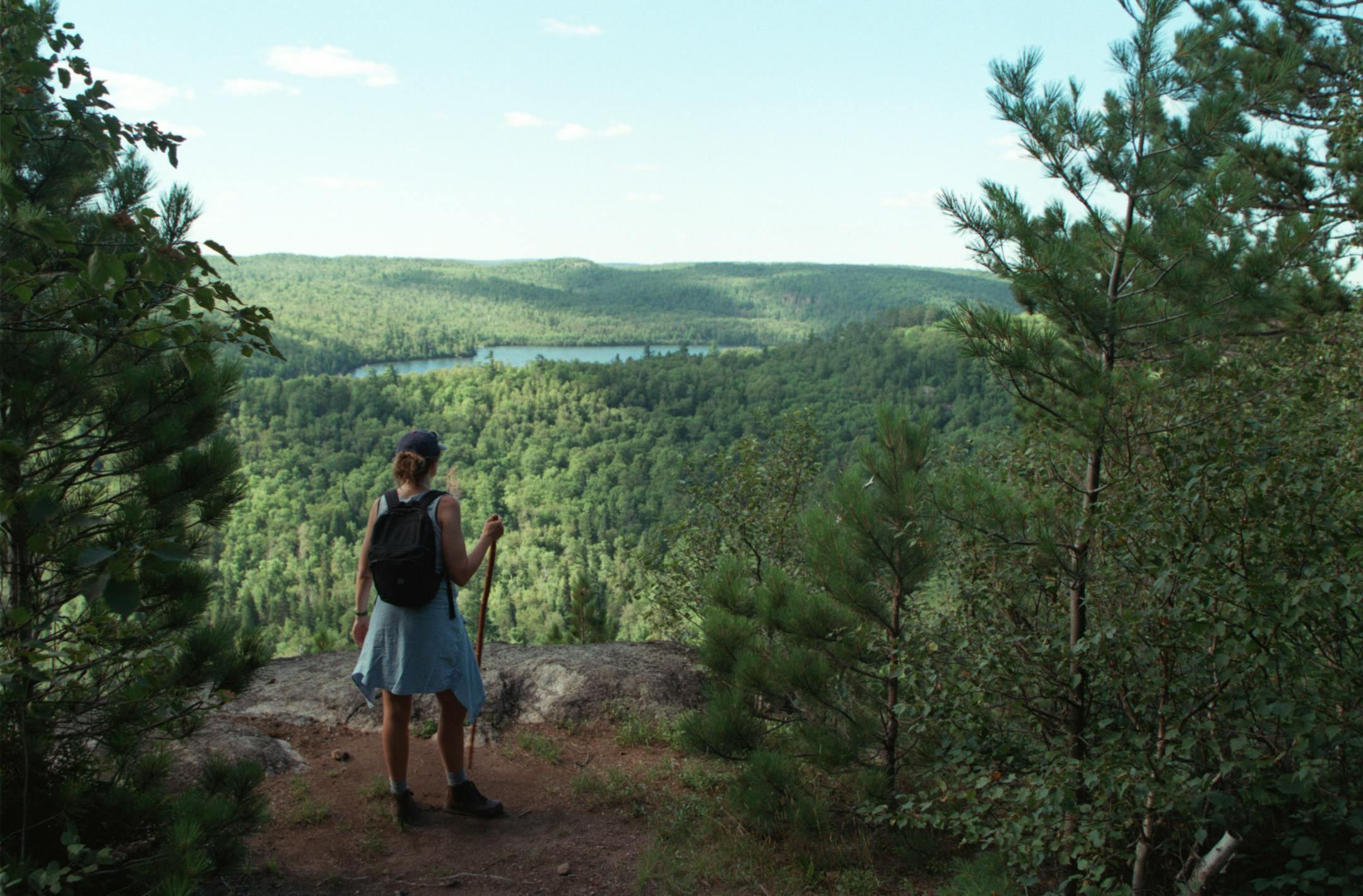 A hiker comes along an overlook of the Palisade Creek Valley and a perfect spot for lunch on Round Mountain on the Superior Hiking Trail on Minnesota's North Shore.