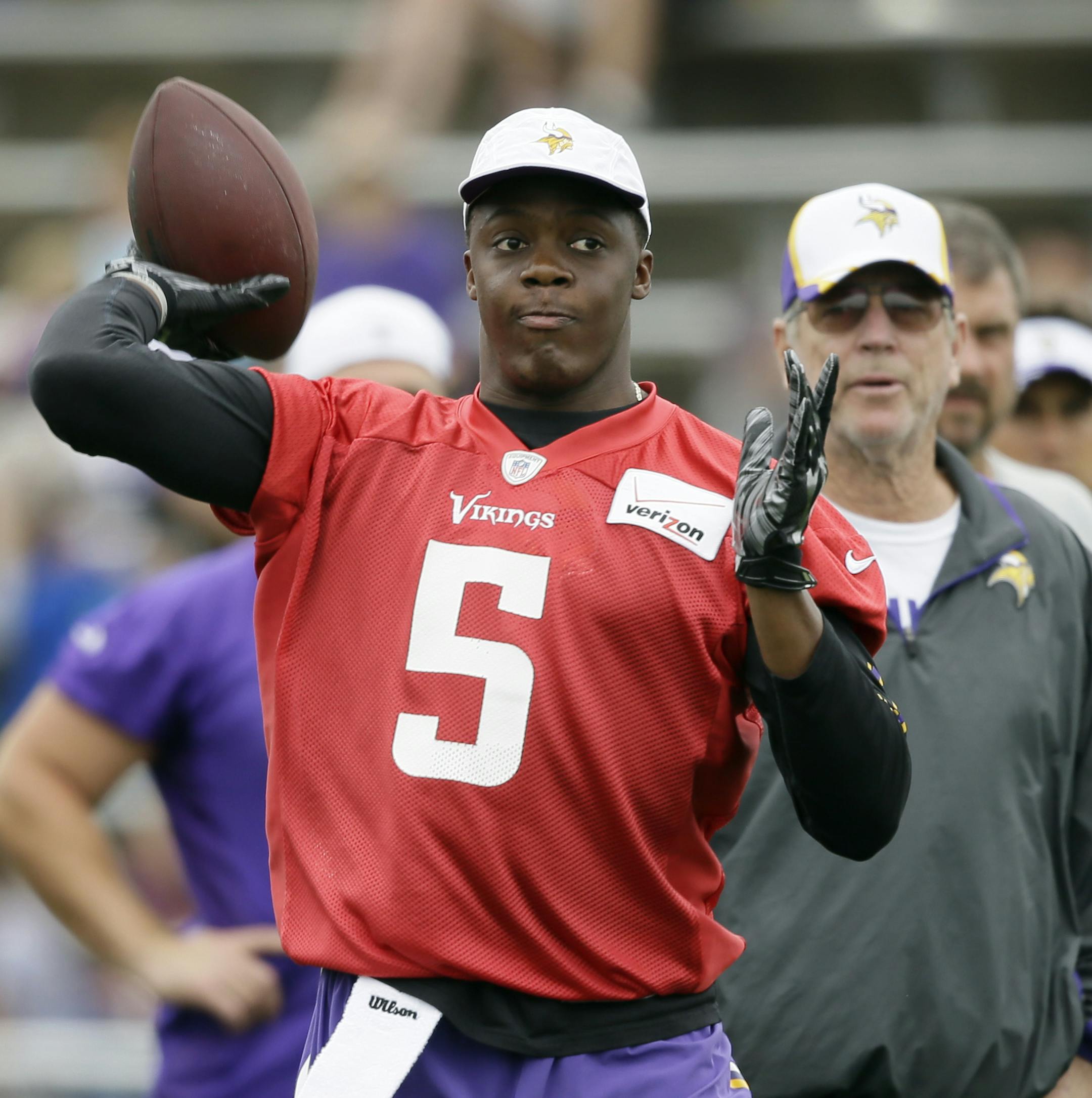 Minnesota Vikings quarterback Teddy Bridgewater throws a pass as offensive coordinator Norv Turner, right, looks on during NFL football training camp, Monday, July 28, 2014, in Mankato, Minn. (AP Photo/Charlie Neibergall) ORG XMIT: MIN2014072917221343