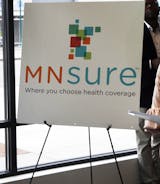 In this Oct. 26, 2017, photo, a woman walks past the Briva Health enrollment office for MNsure, Minnesota's insurance marketplace, in Minneapolis. Health care consumers in most of the country are encountering a world of confusion and chaos as the open enrollment period to sign up for coverage approaches. The outlook is decidedly different in the 12 states that operate their own marketplaces. California, Colorado, Minnesota and other states that operate autonomous exchanges are pulling out all th