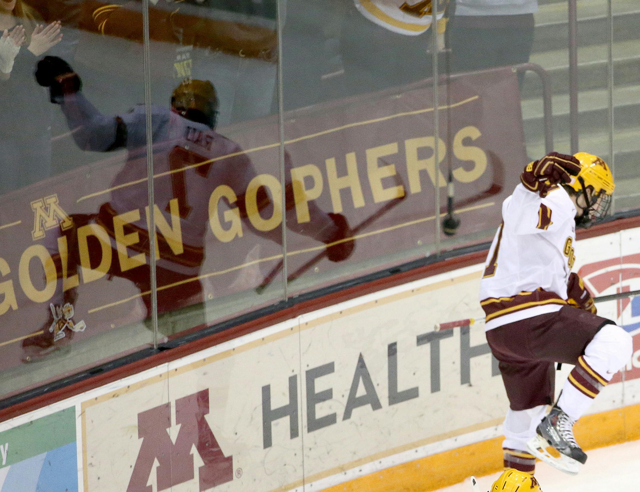 The University of Minnesota's Kyle Rau (7) celebrates the game's first goal against the University of Michigan during the first period as he is reflected in the boards Friday, Feb. 13, 2015.](DAVID JOLES/STARTRIBUNE)djoles@startribune.com The University of Minnesota men's hockey versus the University of Michigan Friday, Feb. 13, 2015.