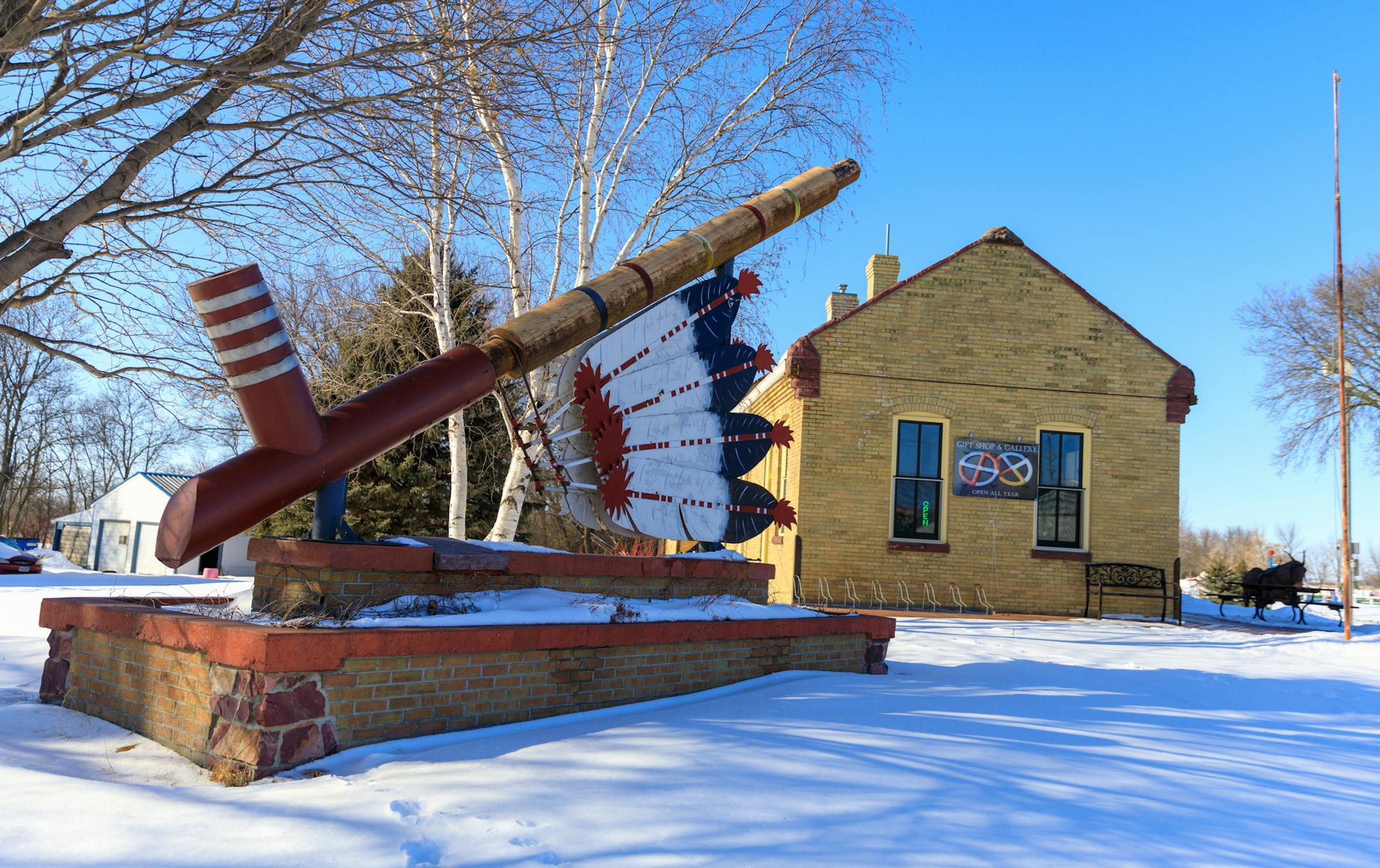 This giant peace pipe stands outside a historic rail station in Pipestone that now houses a gift shop run by Bud Johnston. American Indians describe Pipestone as a crossroads where all people who come in peace are welcome, but a recent racist incident has challenged the town to face up to some shortcomings.