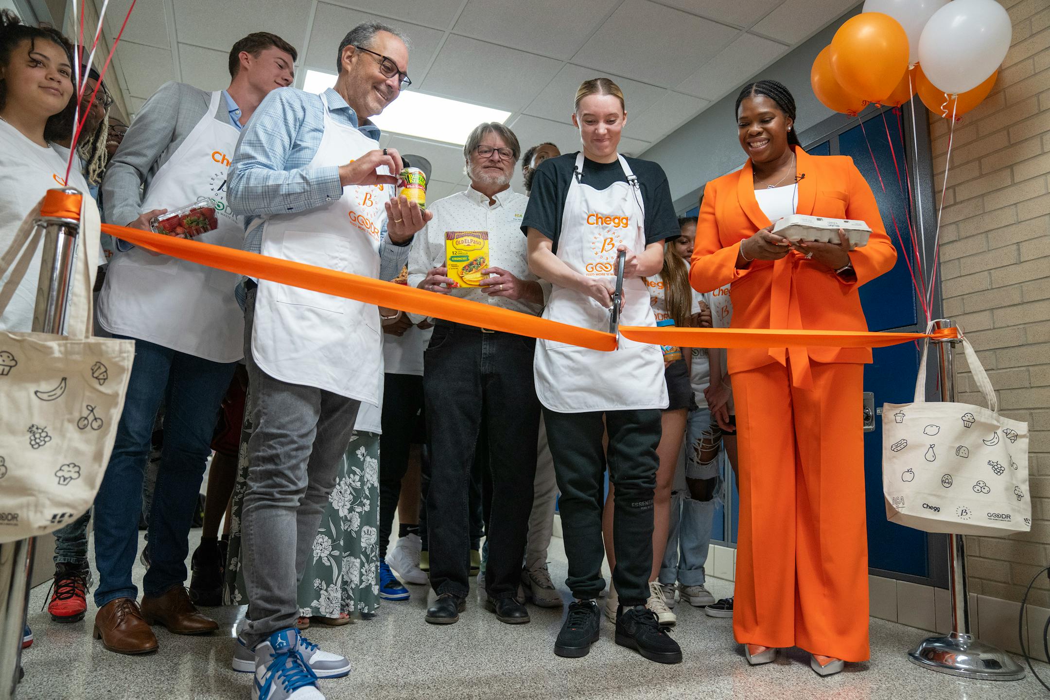 Paige Bueckers cuts the ribbon during a grand opening ceremony for a new free grocery store.