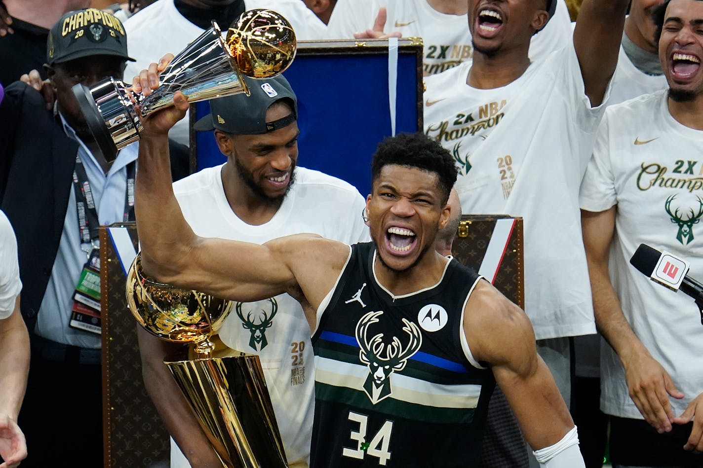 Milwaukee Bucks forward Giannis Antetokounmpo holds up the most valuable player trophy after Game 6 of basketball's NBA Finals against the Phoenix Suns in Milwaukee, Tuesday, July 20, 2021. (AP Photo/Paul Sancya)