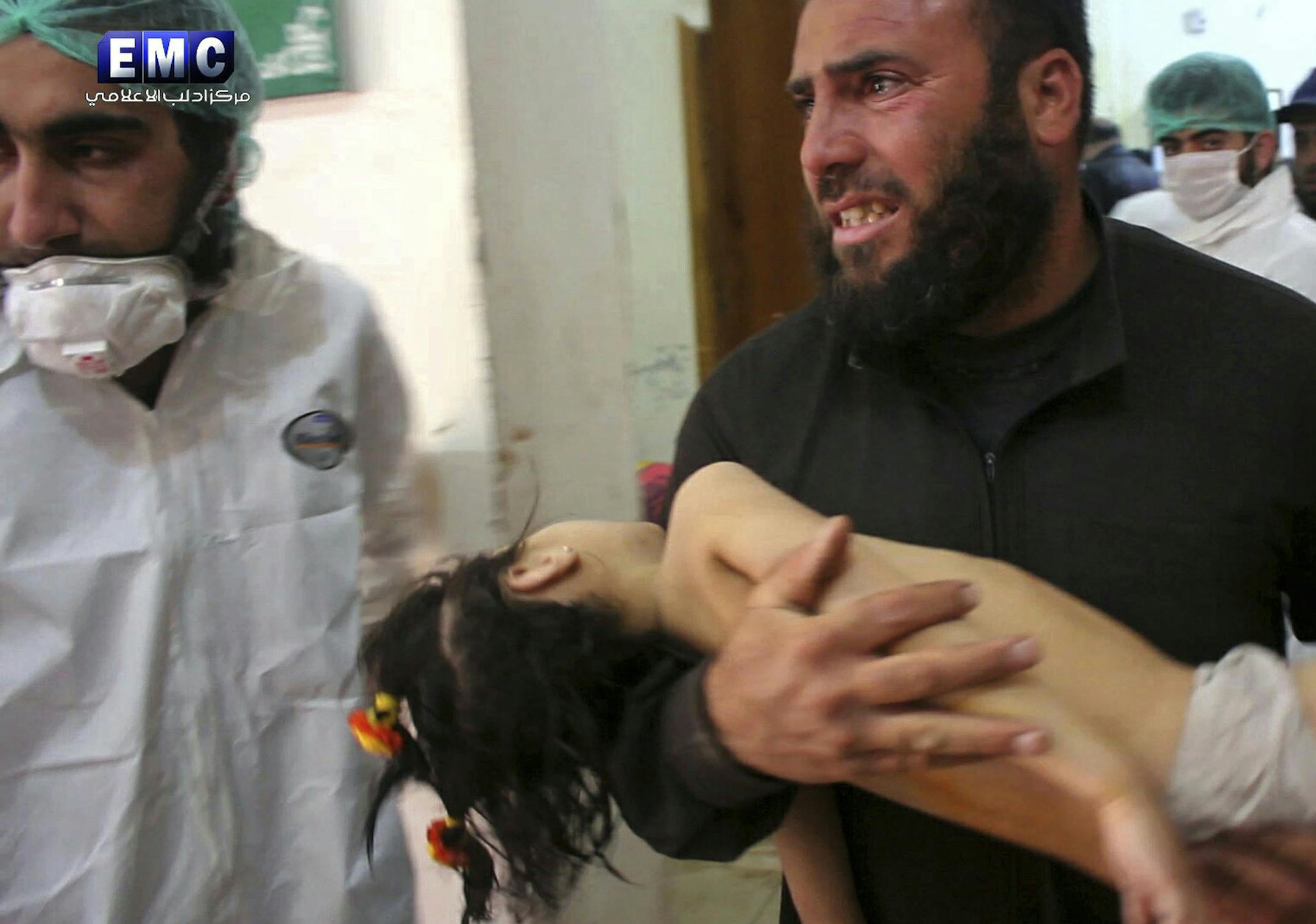 FILE -- This Tuesday April 4, 2017, file photo, provided by the Syrian anti-government activist group Edlib Media Center, that is consistent with independent AP reporting, shows a man carrying a child following a suspected chemical attack, at a makeshift hospital in the town of Khan Sheikhoun, northern Idlib province, Syria. Walid Moallem, Syria's Foreign Minister, told reporters Thursday, April 6, 2017, that it didn't use chemical weapons in Tuesday's attack, and he blamed the rebels for stockp