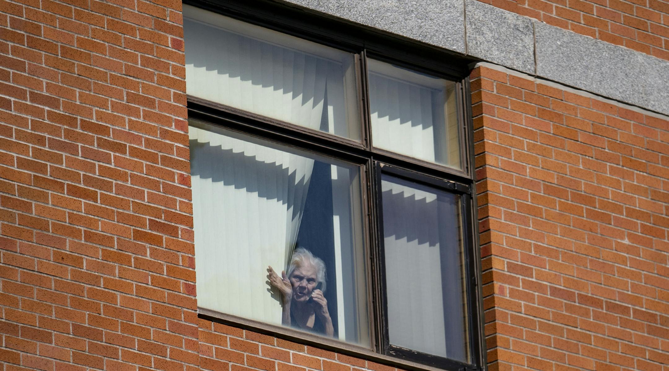 Rose Crist waved down to her daughter, Deana Walkowiak-Olson, from her fourth floor window at St. Ann's Residence in Duluth, MN on Thursday. ] ALEX KORMANN • alex.kormann@startribune.com Deana Walkowiak-Olson has an elderly mother, Rose Crist, who lives at St. Ann's Residence, an assisted-living facility in downtown Duluth. On Thursday, Walkowiak-Olson dropped off some food for her mother at the front door of St. Ann's, and waved at her mother from the lawn next to the home.