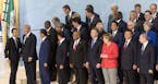 French President Emmanuel Macron and U.S. President Donald Trump talk while world leaders gather for a group photo during the G-20 summit in Hamburg, 