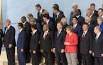 French President Emmanuel Macron and U.S. President Donald Trump talk while world leaders gather for a group photo during the G-20 summit in Hamburg, 