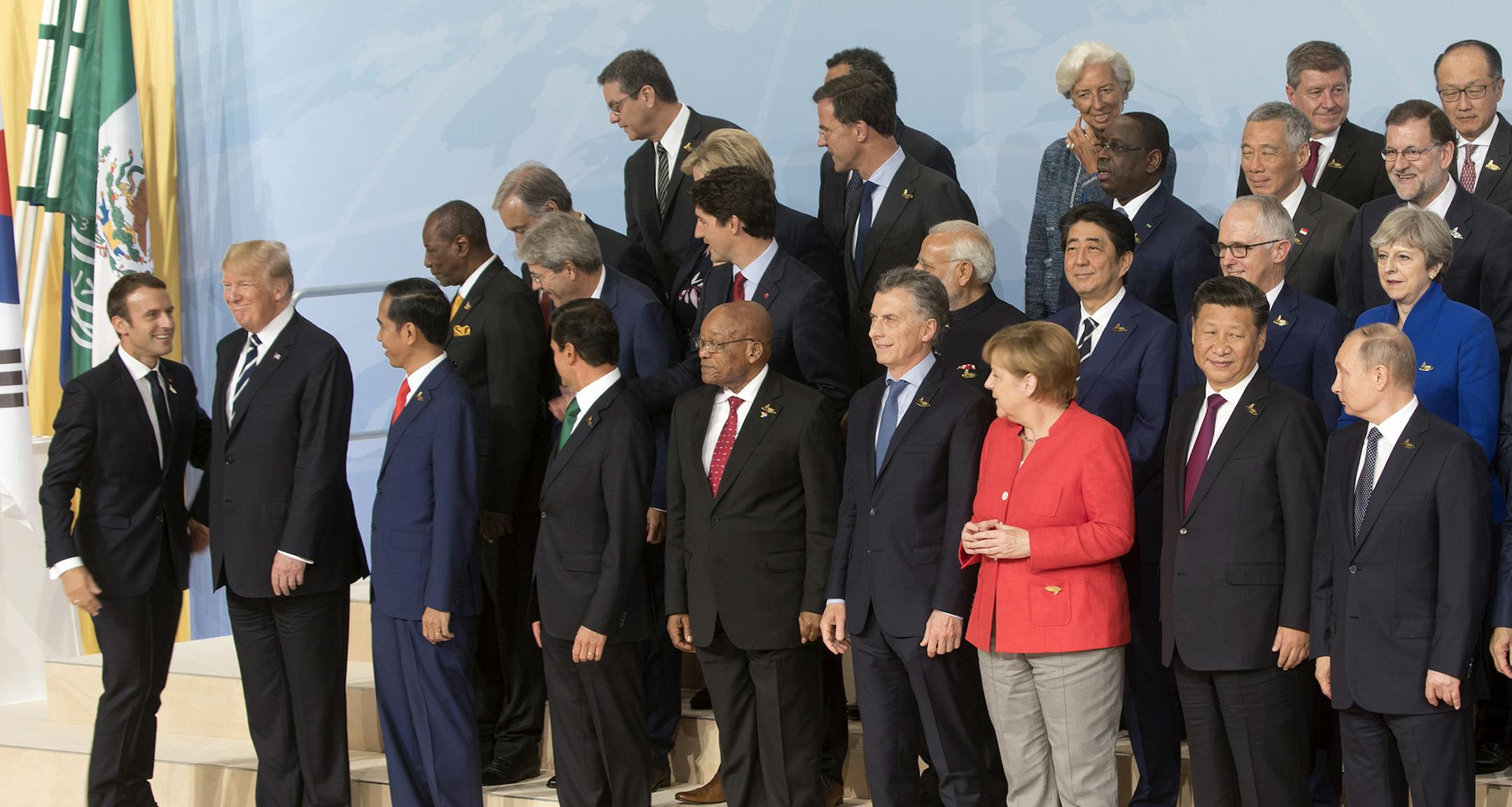 French President Emmanuel Macron and U.S. President Donald Trump talk while world leaders gather for a group photo during the G-20 summit in Hamburg, Germany, July 7, 2017. Front row, from left: Macron, Trump, Indonesian President Joko Widodo, Mexican President Enrique PeÒa Nieto, South African President Jacob Zuma, Argentina's President Mauricio Macri, German Chancellor Angela Merkel, Chinese President Xi Jinping and Russian President Vladimir Putin. (Stephen Crowley/The New York Times) OR