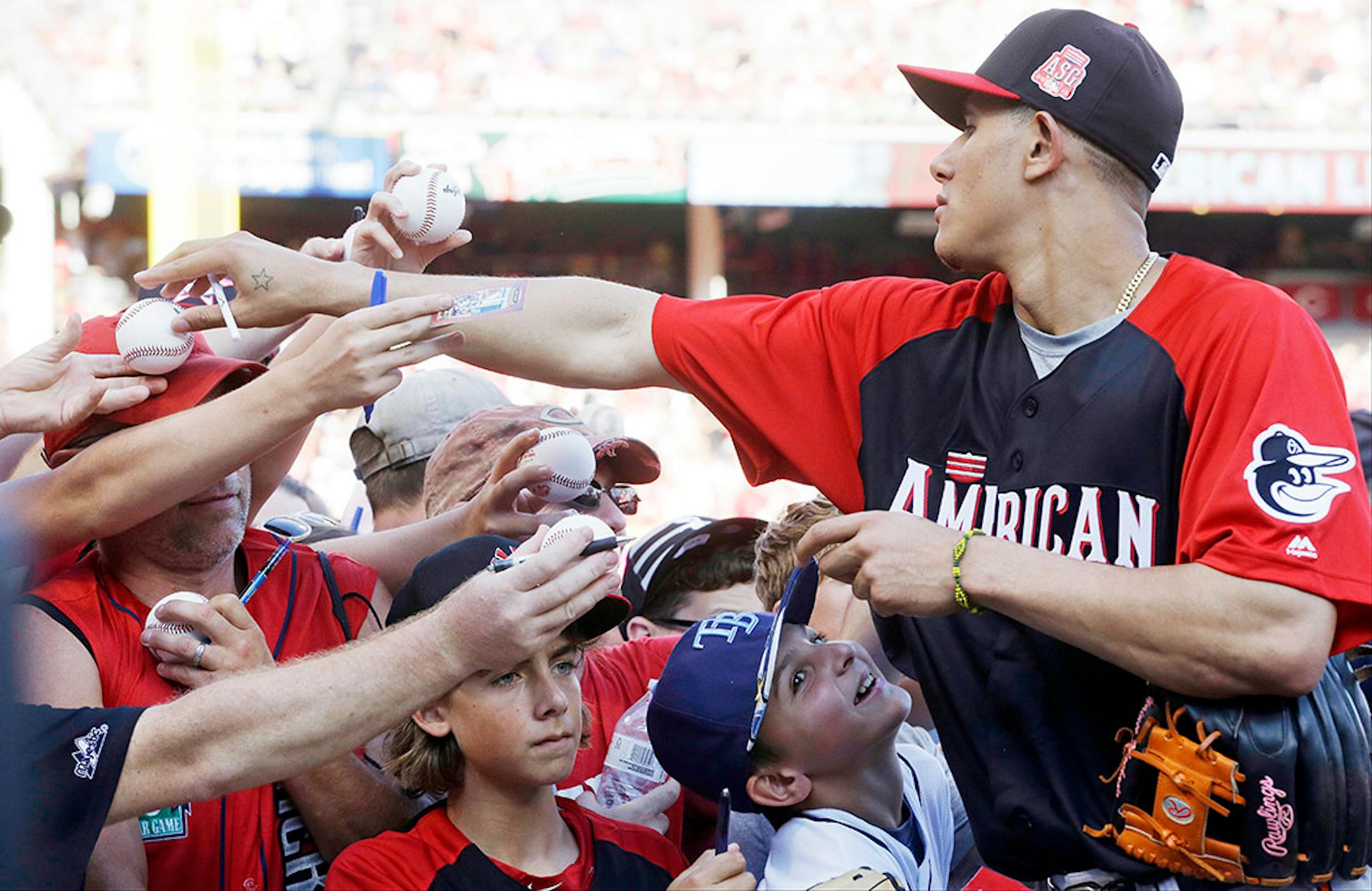 American League's Manny Machado, of the Baltimore Orioles, signs autographs for fans before the MLB All-Star baseball game, Tuesday, July 14, 2015, in Cincinnati.