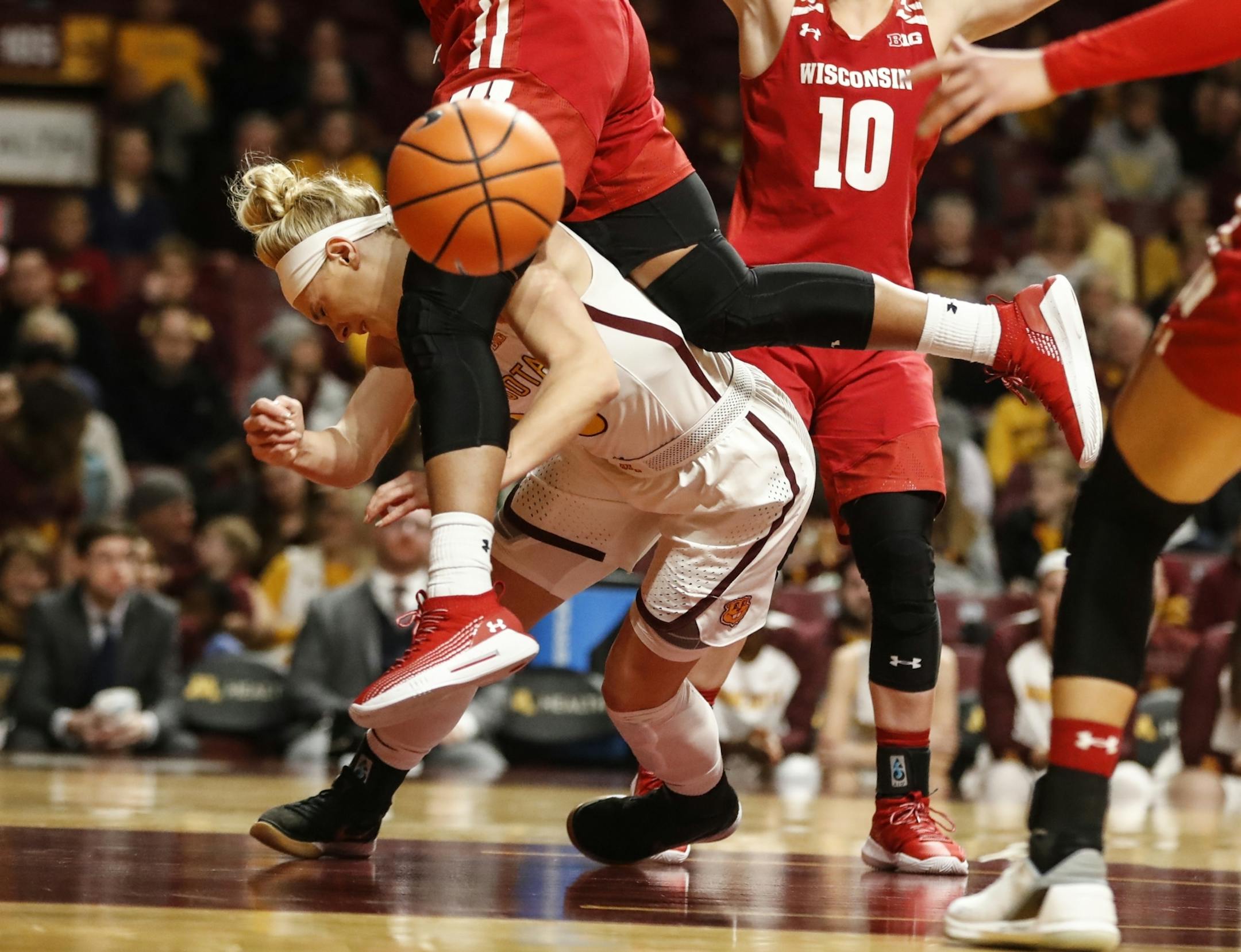 Minnesota Golden Gophers guard Carlie Wagner (33) got trapped under Wisconsin Badgers Marsha Howard's (11) legs during a dive for a rebound in the second half.