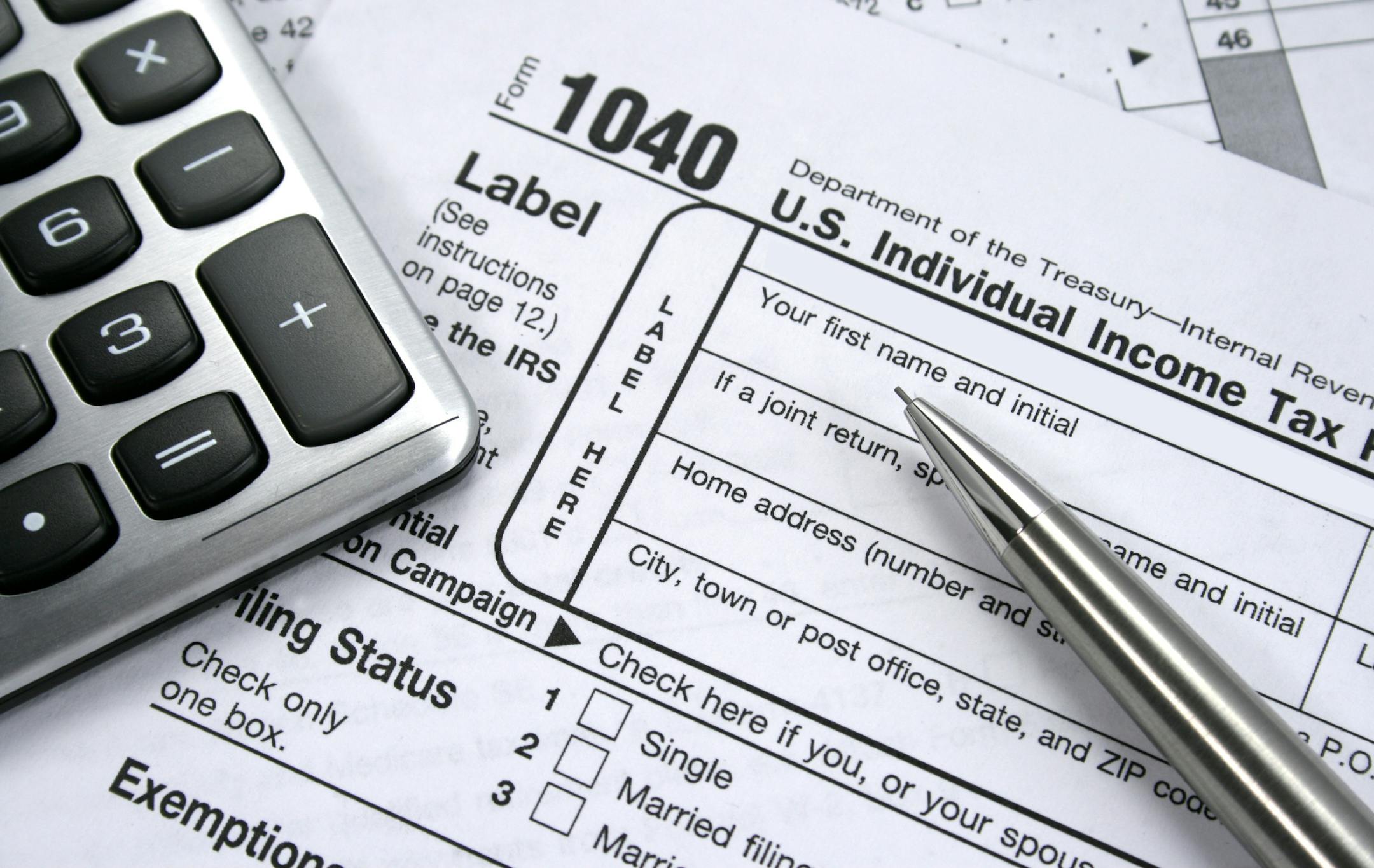 iStockphoto.com A 1040 Individual tax form with calculator and pencil.
