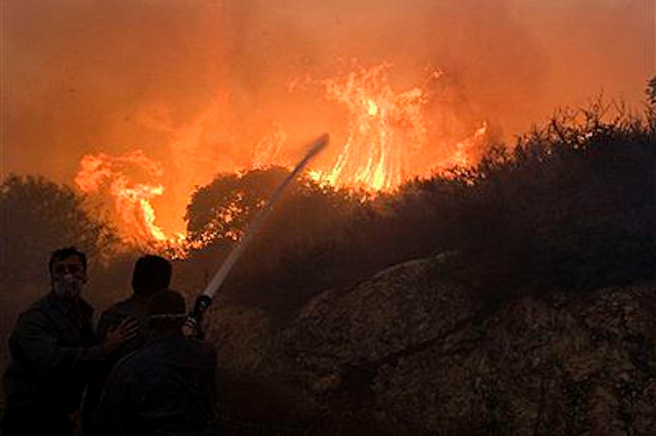 Firefighters try to extinguish the flames in Tirat Hacarmel, northern Israel, Friday, Dec. 3, 2010. TCrews and equipment from around the world began arriving on Friday to help Israel's worst fire ever. The inferno, which also displaced thousands, is still raging through forests in northern Israel and on the outskirts of the country's third largest city, Haifa. (AP Photo/Sebastian Scheiner)