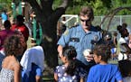 1: Commander Matt Toupal passed out stickers at a St. Paul Safe Summer Nights event. On August 26, there will be a Safe Summer Nights event in Brookly