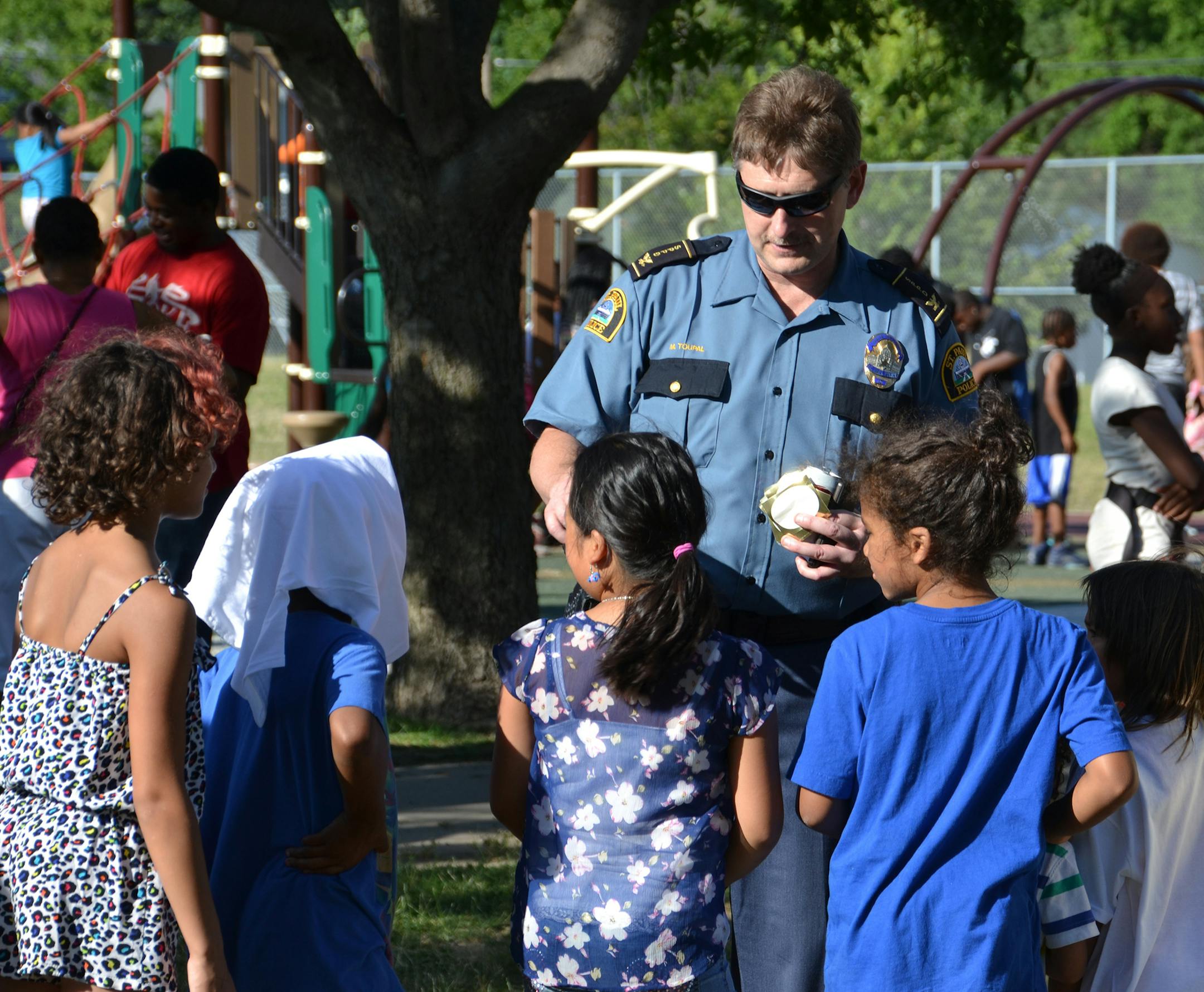 1: Commander Matt Toupal passed out stickers at a St. Paul Safe Summer Nights event. On August 26, there will be a Safe Summer Nights event in Brooklyn Center. (Photo by Holly Evans-Wardlaw)