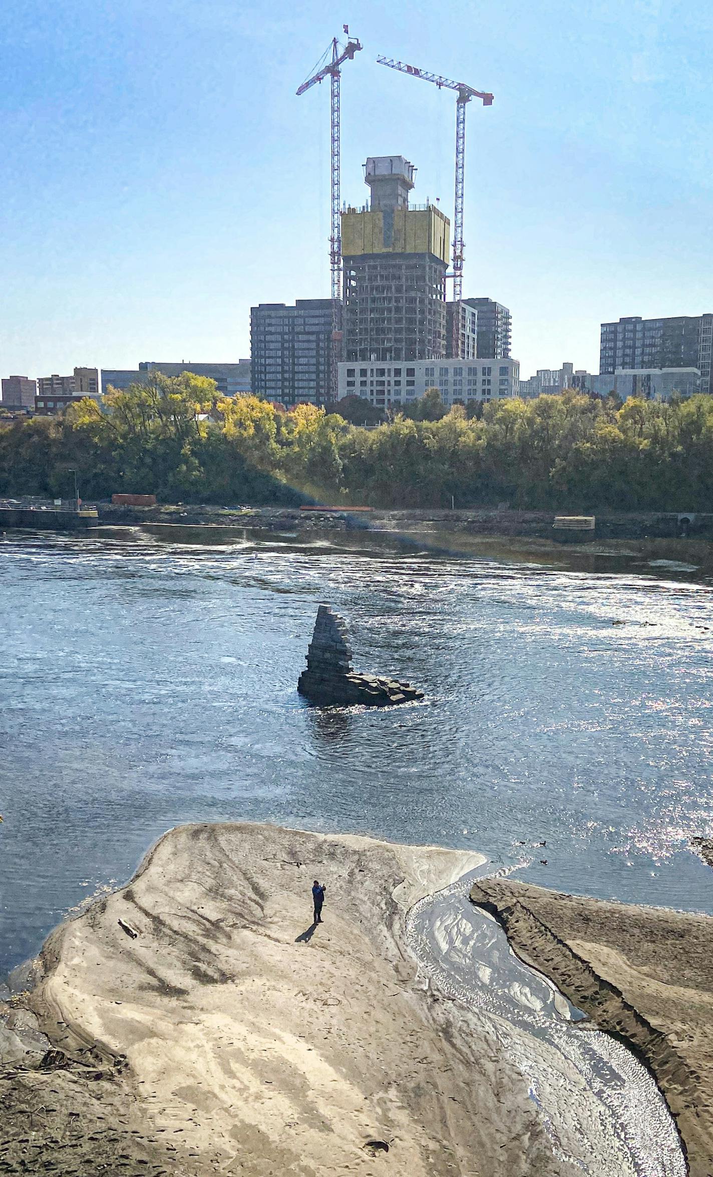 People wandered the Mississippi River bottom Monday afternoon below the Stone Arch Bridge as the Army Corps of Engineers lowered the river to allow inspection of the upper and lower lock and dams.