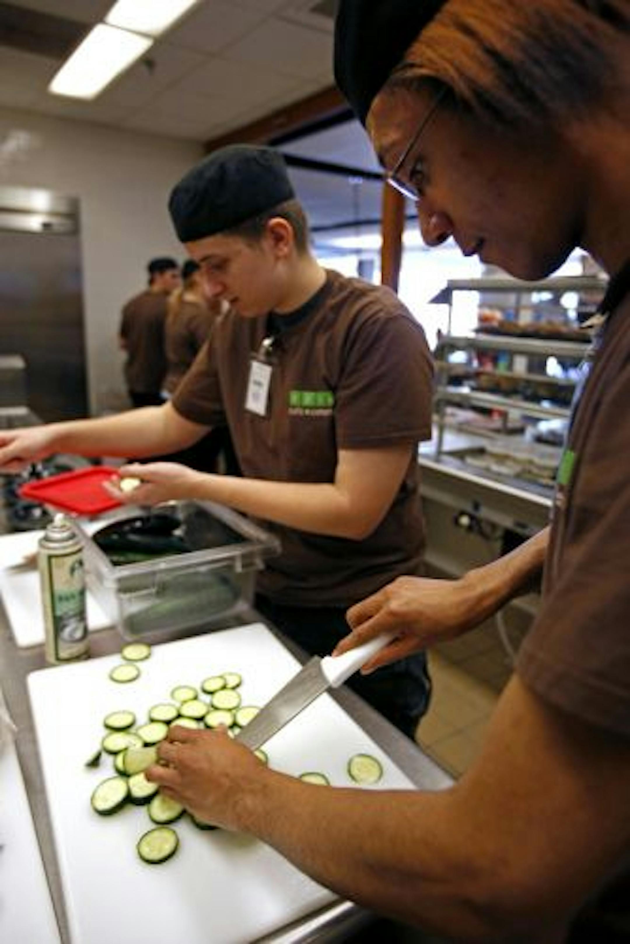 A partnership between Dakota County, School District 197 and the local Green Mill in Hastings has created a new cafeteria at the Judicial Center in Hastings. Students Cory Vinge (left) and Wesley Pate (right) prepare the lunch menu.