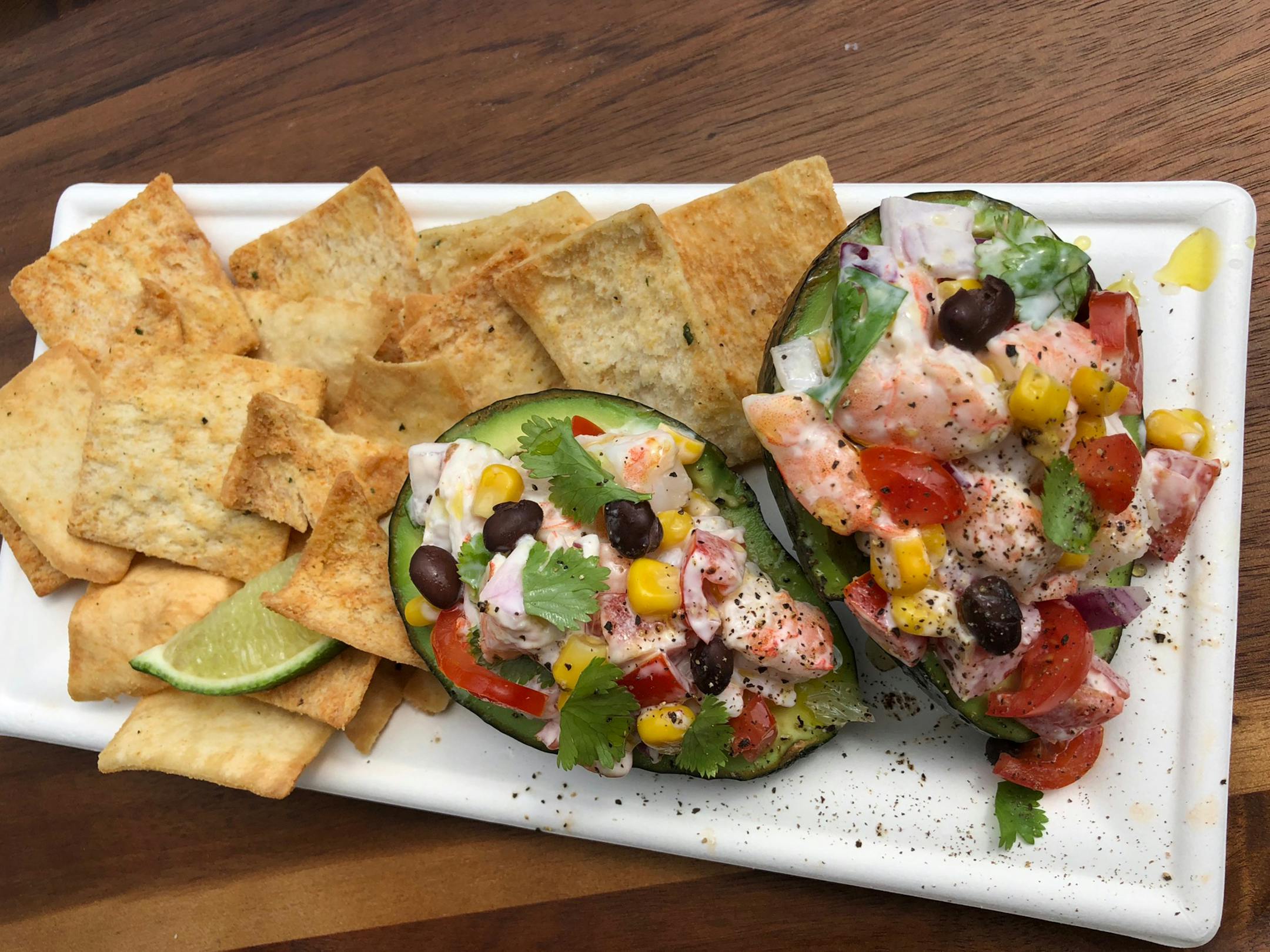 Firecracker Shrimp Stuffed Avocado: Gulf white shrimp tossed with lime, onion, black beans, tomato and fire-roasted corn in a garlic aioli, drizzled with cilantro-infused olive oil, stuffed in avocado halves and served open-face with flatbread. At The Hideaway Speakeasy, located in the Veranda, Grandstand upper level, northwest section.