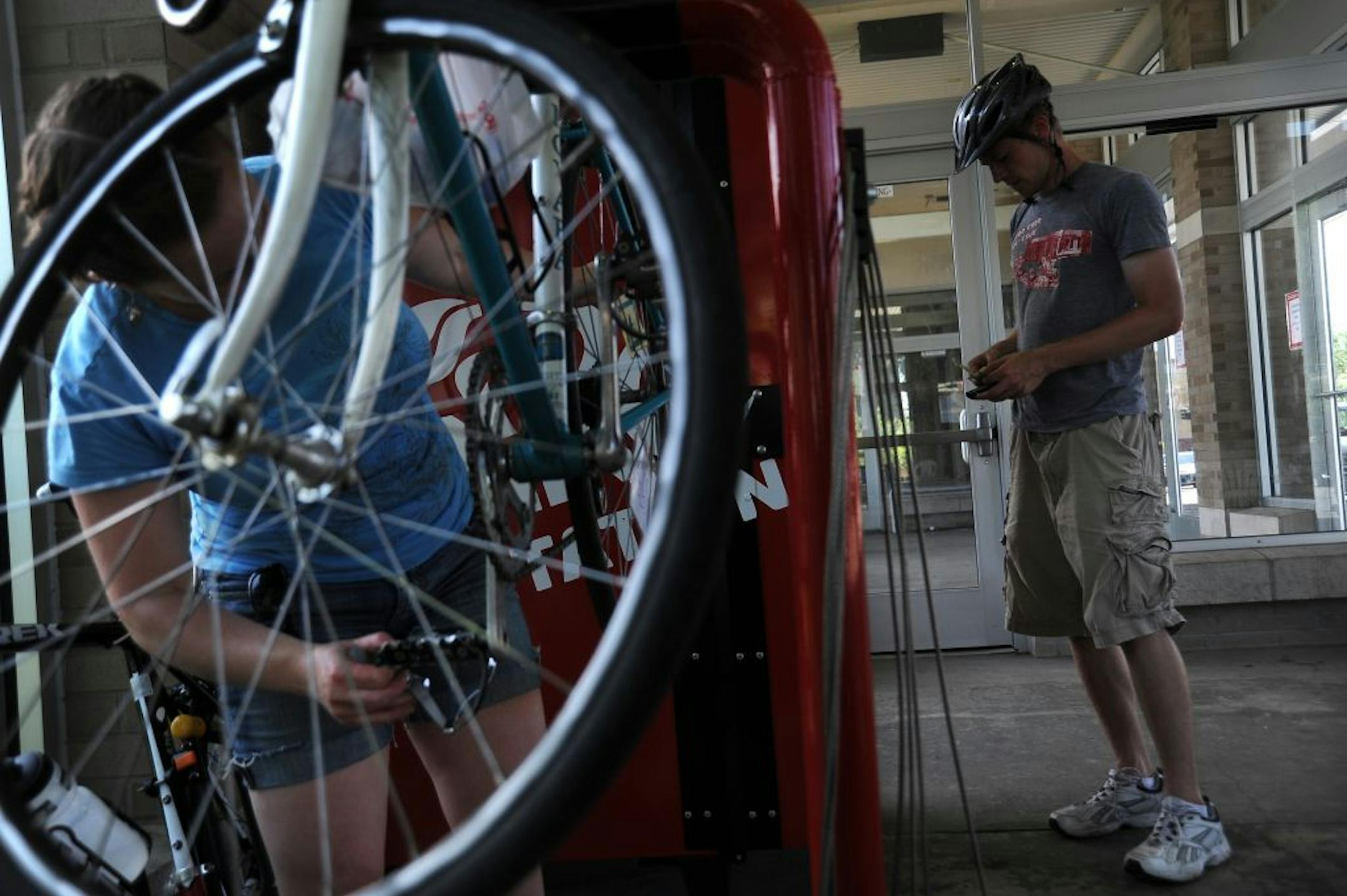 Natalie Wagner and Matt Lewis stopped for a bike checkup and beverage from the Bike Fixation vending machine at a transit shelter in Uptown Minneapolis.
