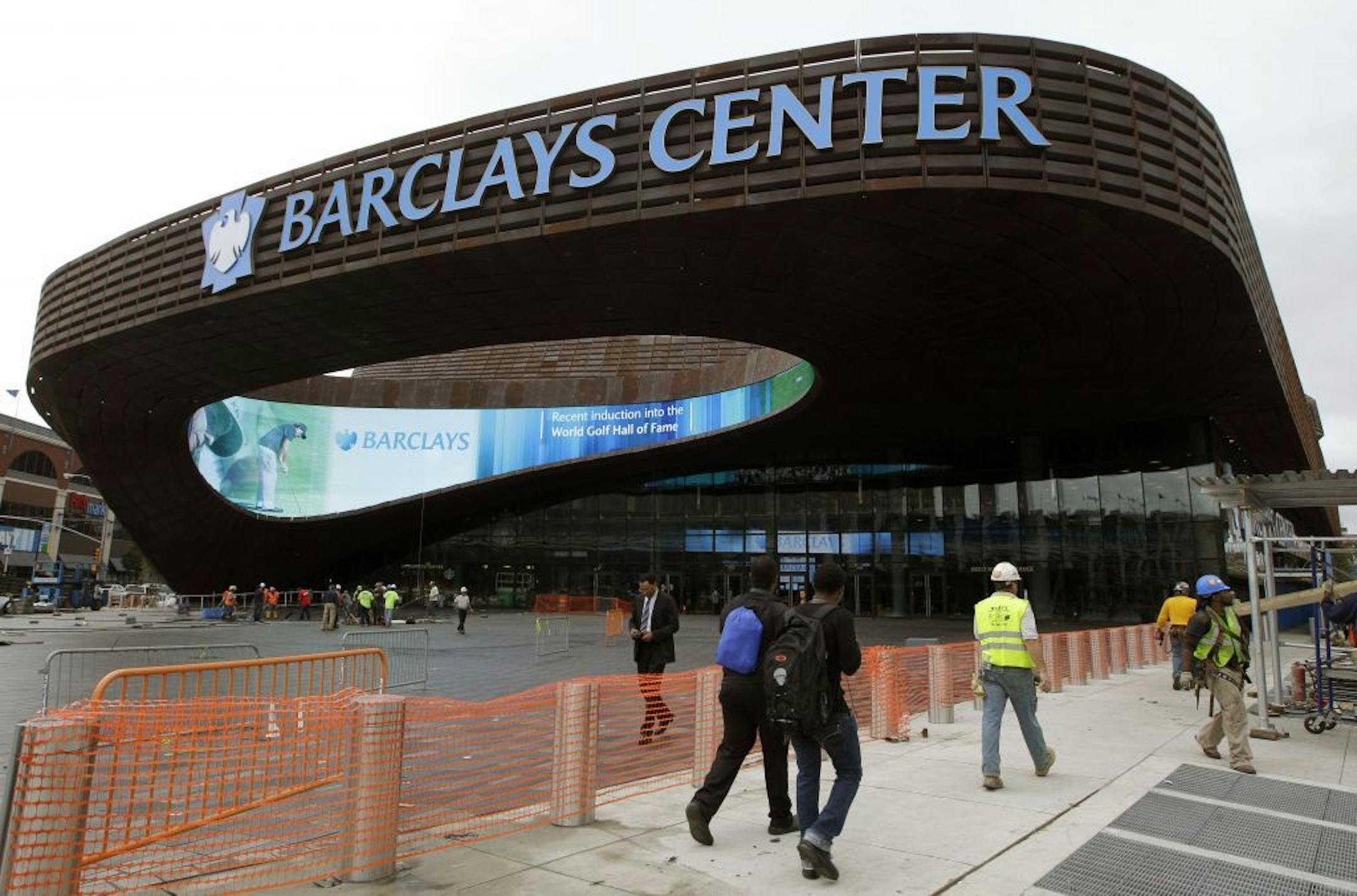 Pedestrians pass the main entrance to the Barclays Arena in New York, Thursday, Sept. 20, 2012 as workmen complete their cleanup for Friday's ribbon-cutting ceremony. A new chapter in Brooklyn's history Friday when the Brooklyn Nets new arena will open, just across the street from the spot where the Dodgers owner once tried to build a baseball stadium that never saw the light of day.