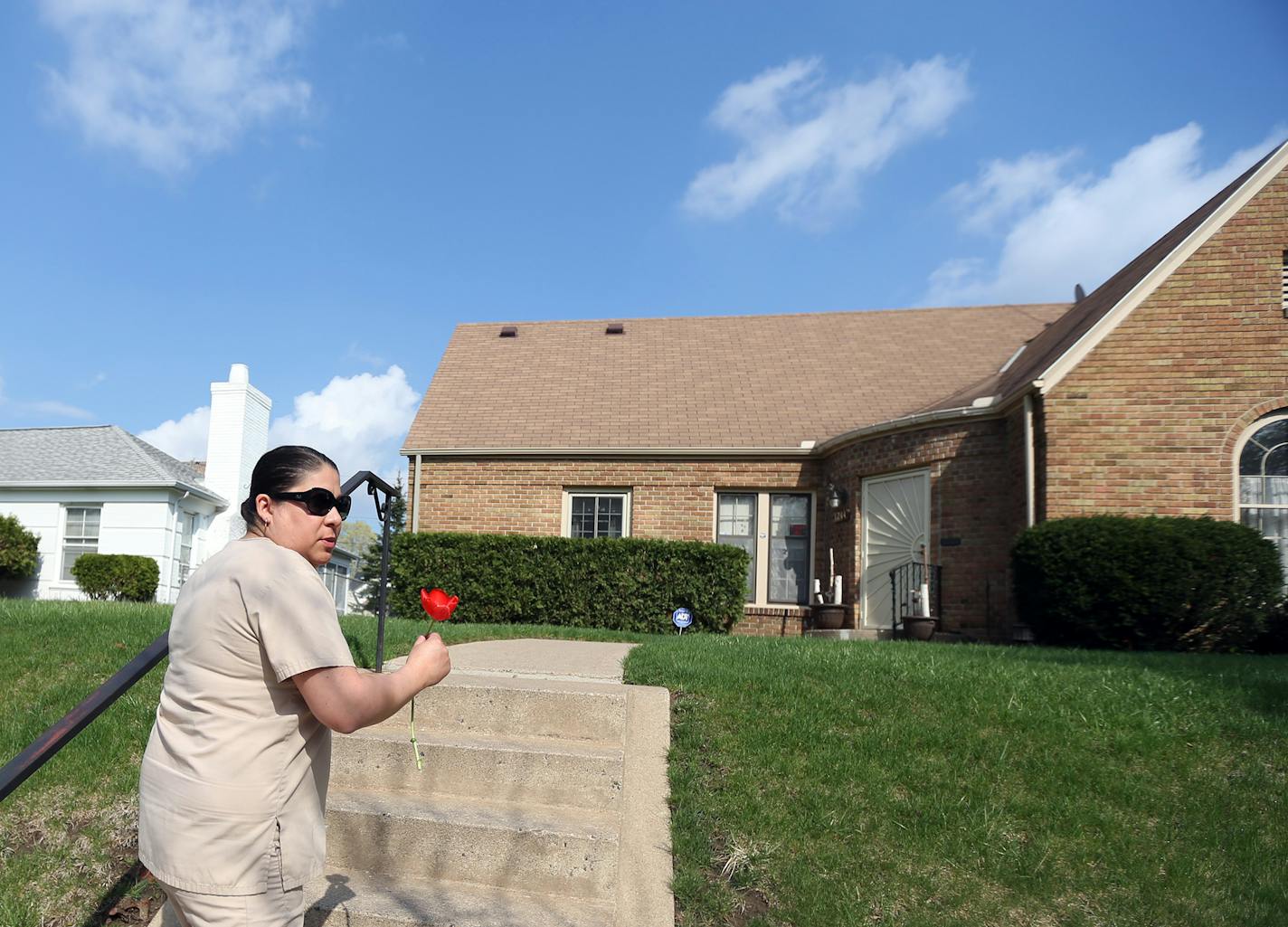 Beth Mejia who grew up in N. Minneapolis dropped a flower of at a home in the 1200 block of Russell avenue N, that is the home where Prince lived as a kid Thursday April 21, 2016 Minneapolis, MN.] Jerry Holt /Jerry.Holt@Startribune.com