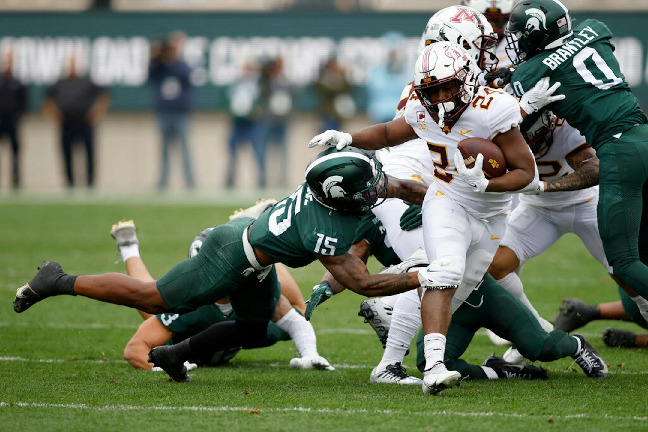 Minnesota's Mohamed Ibrahim (24) rushes against Michigan State's Angelo Grose (15) during the first half of an NCAA college football game, Saturday, Sept. 24, 2022, in East Lansing, Mich. Minnesota won 34-7. (AP Photo/Al Goldis)