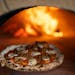 What's becoming a signature feature of Daniel del Prado's restaurant's - a wood fired pizza oven - is the centerpiece of a seating area off the bar an