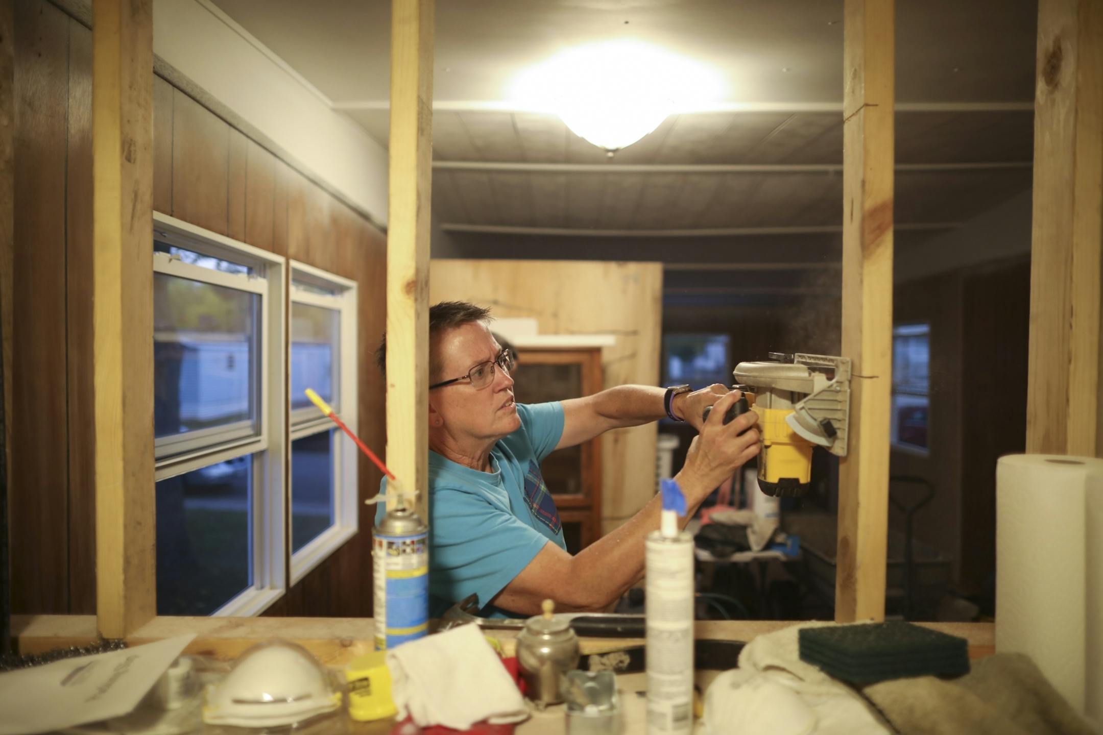 Nancy Robinett used a circular saw to cut through framing lumber in the mobile home in Lakeside Homes park she is helping to rehab for a former Lowry Grove resident.