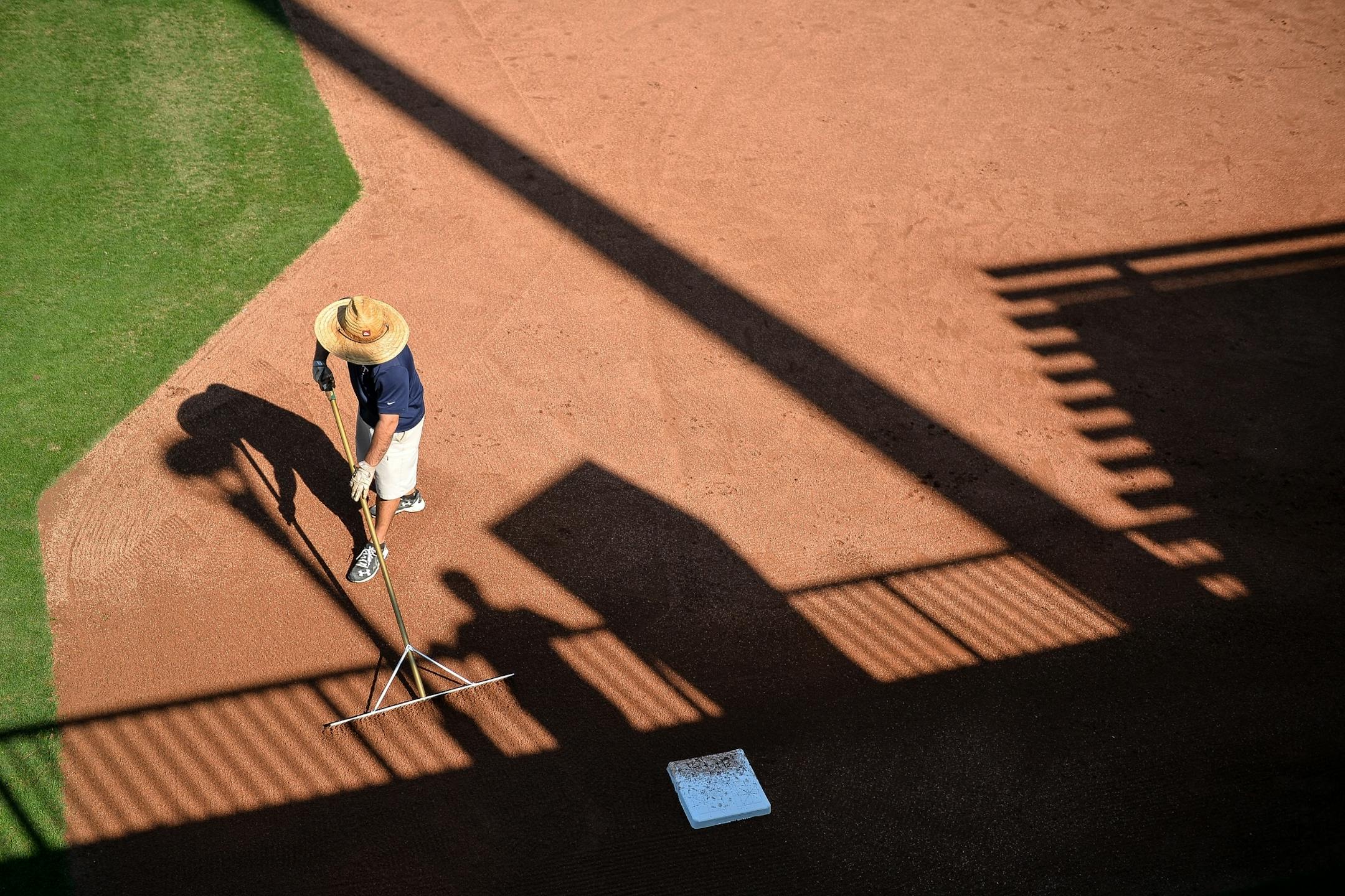 A grounds keeper touched up the dirt on one of the backfields after a pitchers' fielding practice Wednesday.