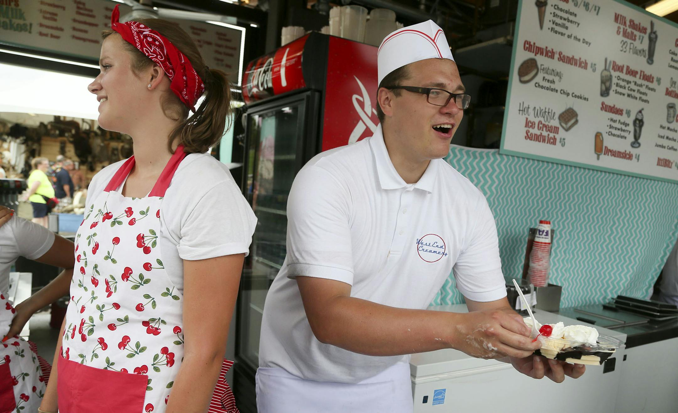 Among the new food establishments available to visitors to the Minnesota State Fair is the West End Creamery seen Thursday, Aug. 21, 2014 in Falcon Heights, MN. Here, employee Jack Revord serves a customer a double hot fudge sunday next to fellow employee Jessie Bremseth.] (DAVID JOLES/STARTRIBUNE) djoles@startribune Annual survey of new foods at the MN State Fair.** Jack Revord, Jessie Bremseth, cq