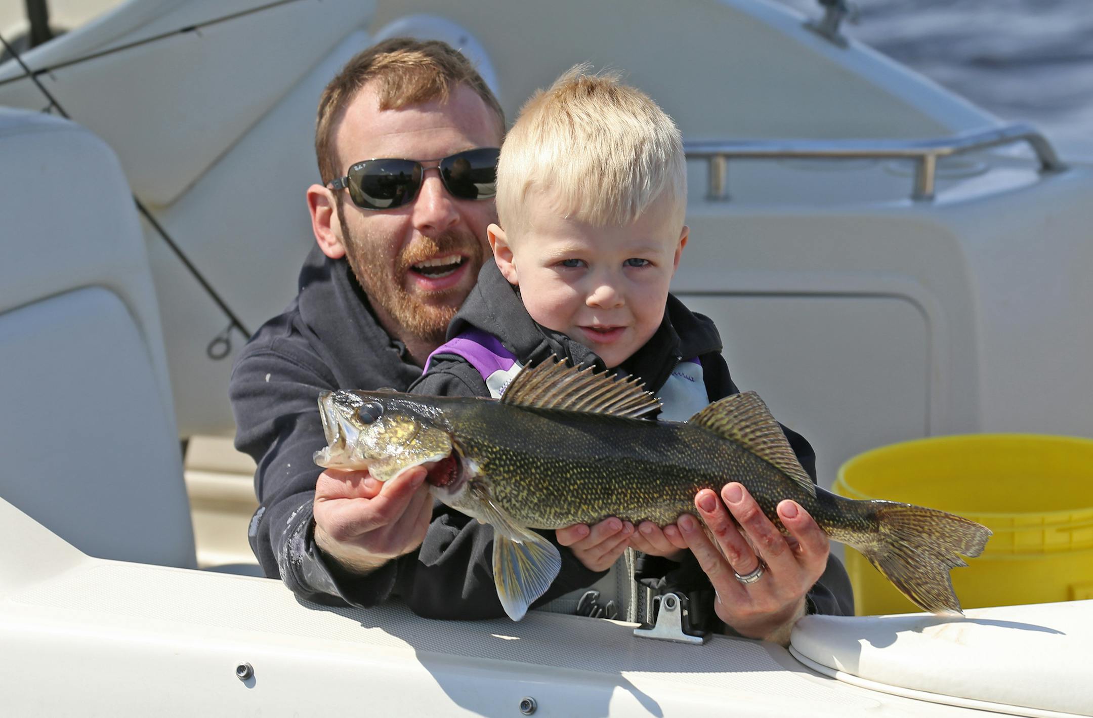 Aaron Hobbs of the Twin Cities area was helped Saturday on Upper Red Lake by his son, Erik, 3, as together they showed off one of the walleyes they boated.