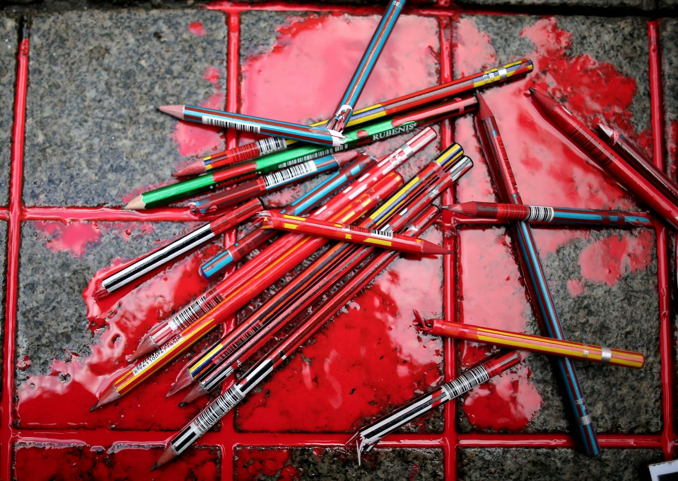 Broken pens lay on the ground as members of a leftist party gather outside the French consulate to pay tribute to the victims of the French satirical newspaper Charlie Hebdo, in Istanbul, Turkey, Friday, Jan. 9, 2015. 12 people were killed on Jan. 7 in a terrorist attack at the Charlie Hebdo headquarters in Paris.