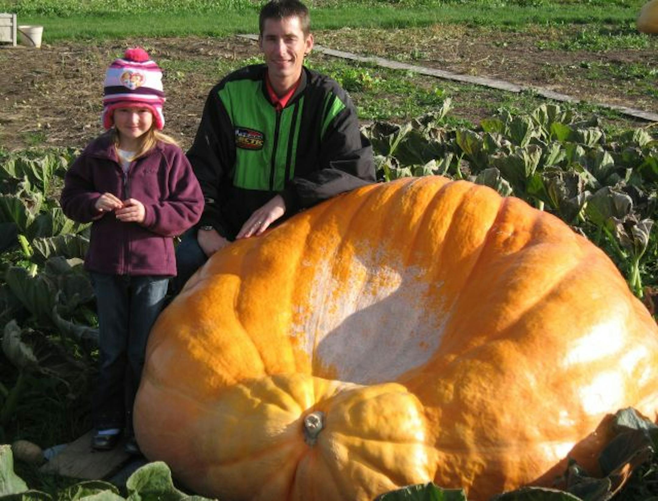 PHOTO BY KEVIN GILES. Cutline: Chris Stevens, shown with his 5-year-old daughter Kaley, will enter this 1,340-pound pumpkin in Stillwater�s giant pumpkin contest on Saturday. The Stevens family grew the pumpkin this summer in their family garden south of New Richmond, Wis.