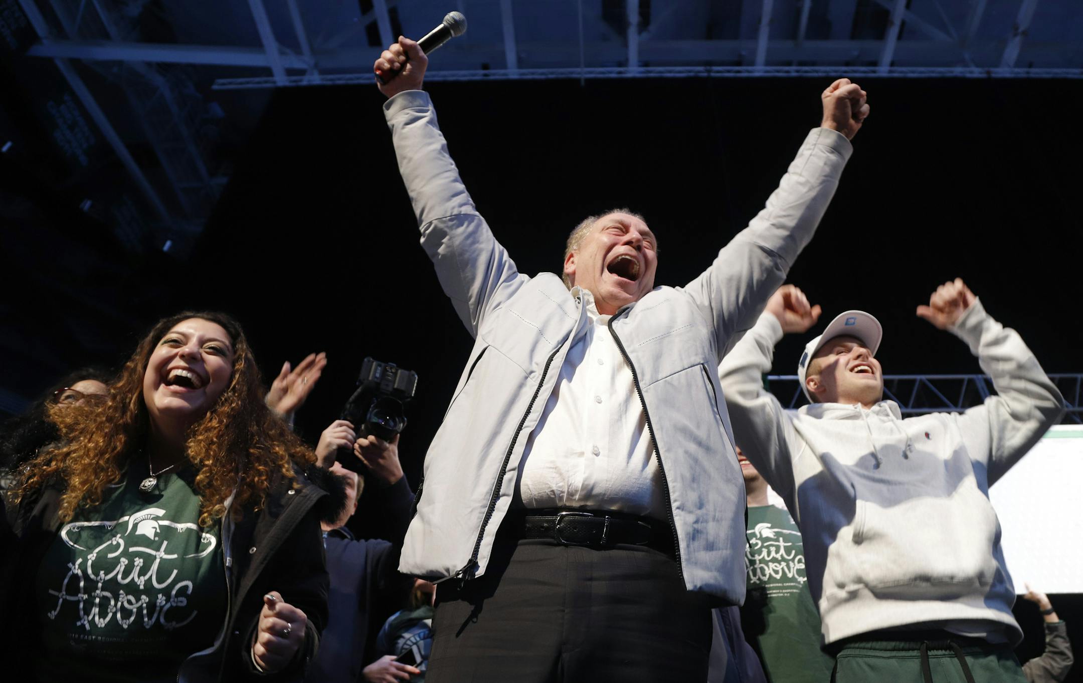 Michigan State coach Tom Izzo reacts at a rally, early Monday, April 1, 2019, in East Lansing, Mich., after returning from their NCAA men's East Regional final college basketball game where they defeated Duke 68-67 to reach the Final Four. Also seen are Izzo's daughter Raquel, left, and player Jack Hoiberg, right. (AP Photo/Al Goldis)