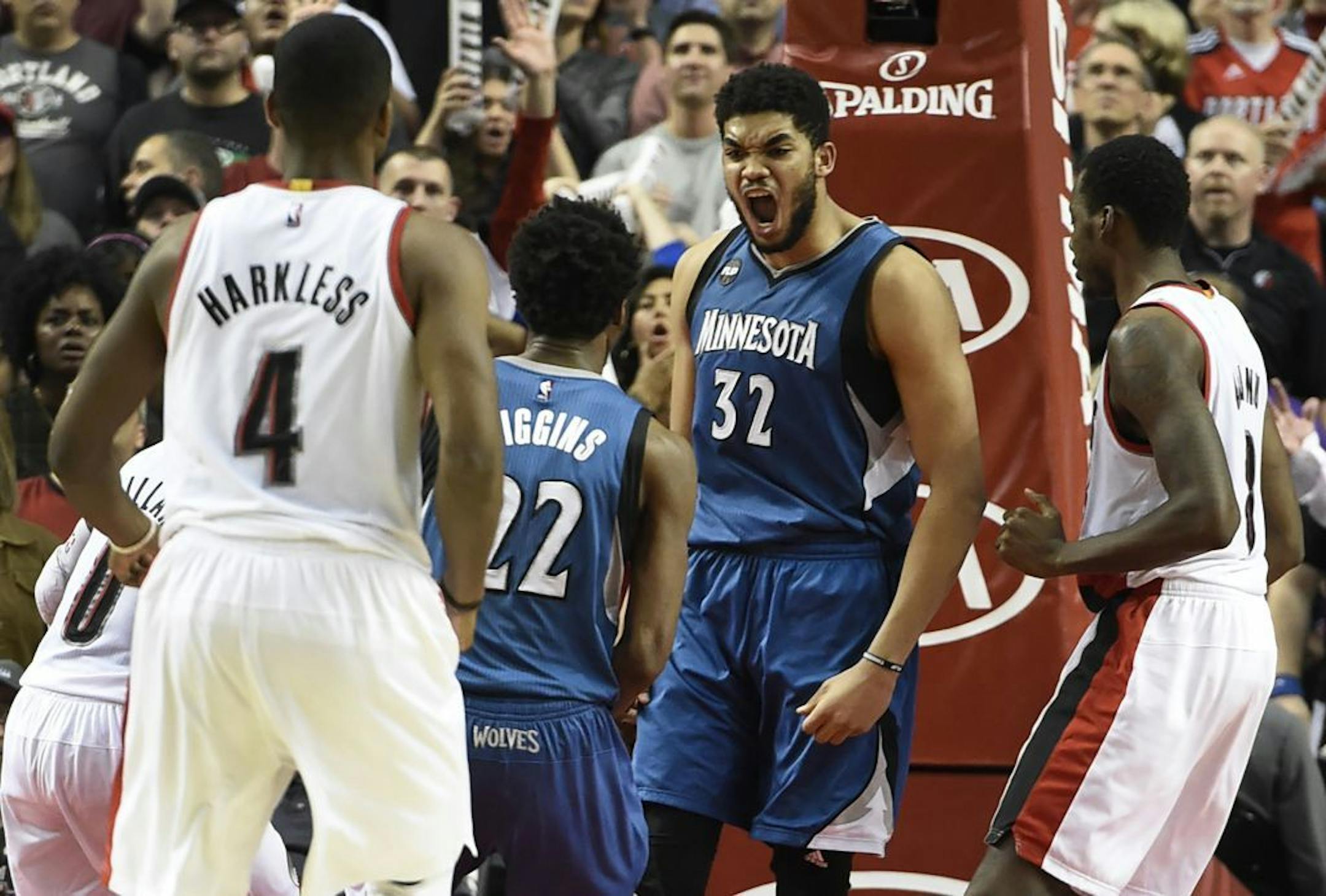 Minnesota Timberwolves center Karl-Anthony Towns (32) celebrates with guard Andrew Wiggins (22) after hitting the game-winning shot during the fourth quarter of an NBA basketball game in Portland, Ore., Saturday, April 9, 2016. The Timberwolves won 106-105.