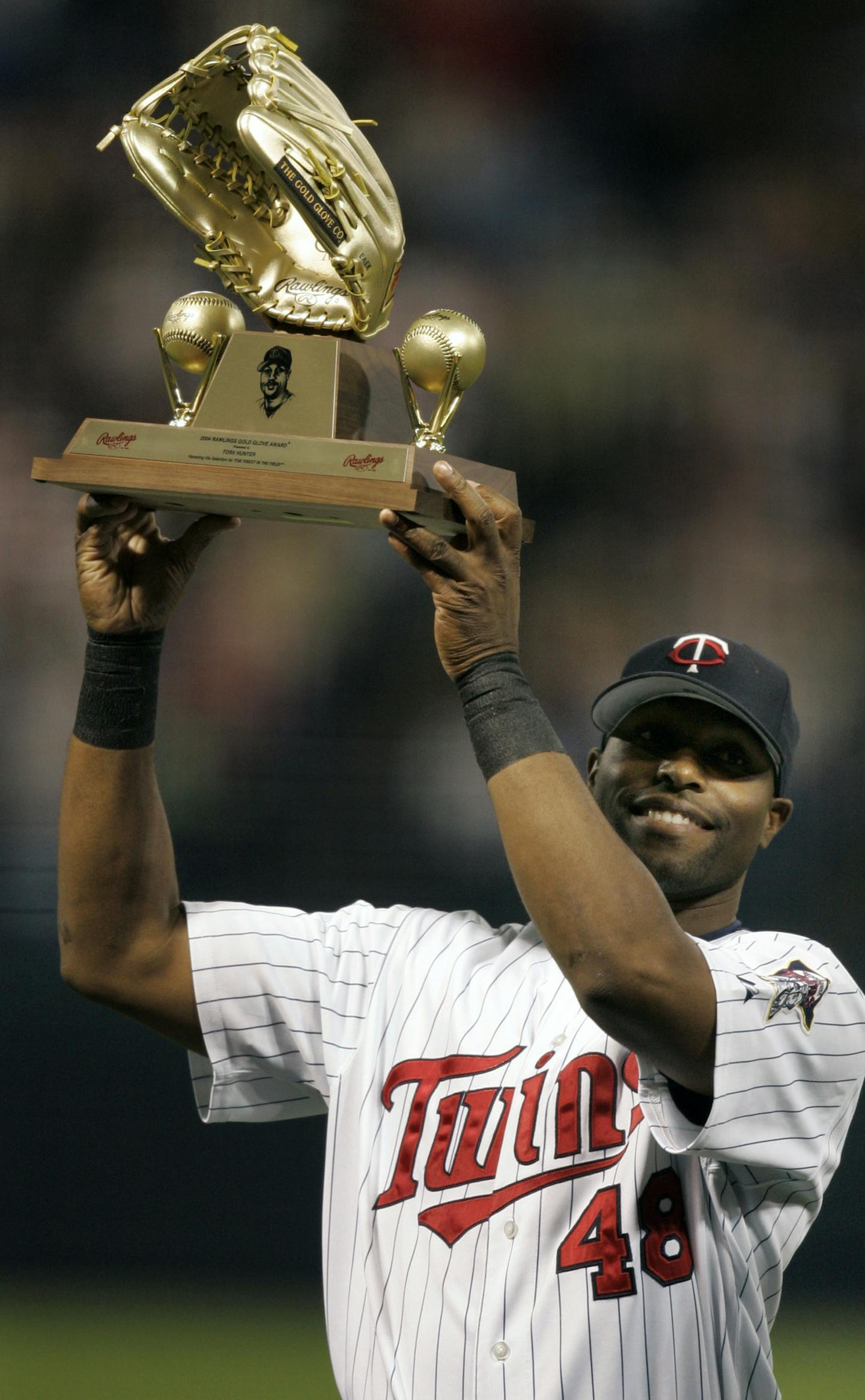 Richard Tsong-Taatarii/Star Tribune Minneapolis,MN;4/30/05;left to right:At the Metrodome, in a game between the LAA and the Twins, Torii Hunter holds up his Gold Glove trophy which he won for his 2004 defensive play.