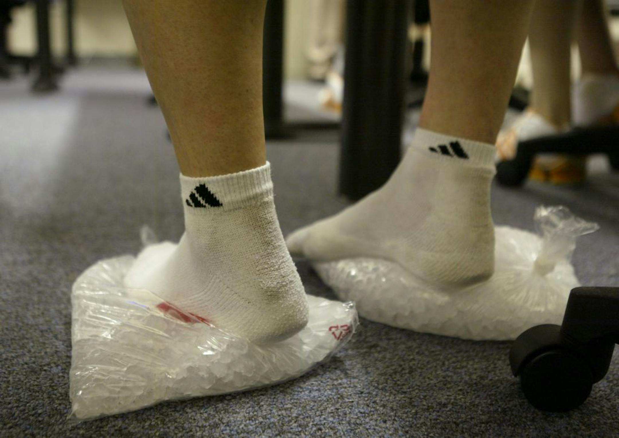 Injured Macalester senior Sara Entgelmeier ices her feet at halftime of the Scots' loss to St. Mary's Monday night at Macalester. She's playing despite the pain from Plantar Fasciitis. GENERAL INFORMATION: Staff photo by Jeff Wheeler ST. PAUL - 12/6/04 - The Macalester College women's basketball program is struggling. They went 1 - 24 last year and it's predicted they'll be even worse this year. Currently 0 - 5, they have only seven women playing for first year coach Jeannine Ruh.