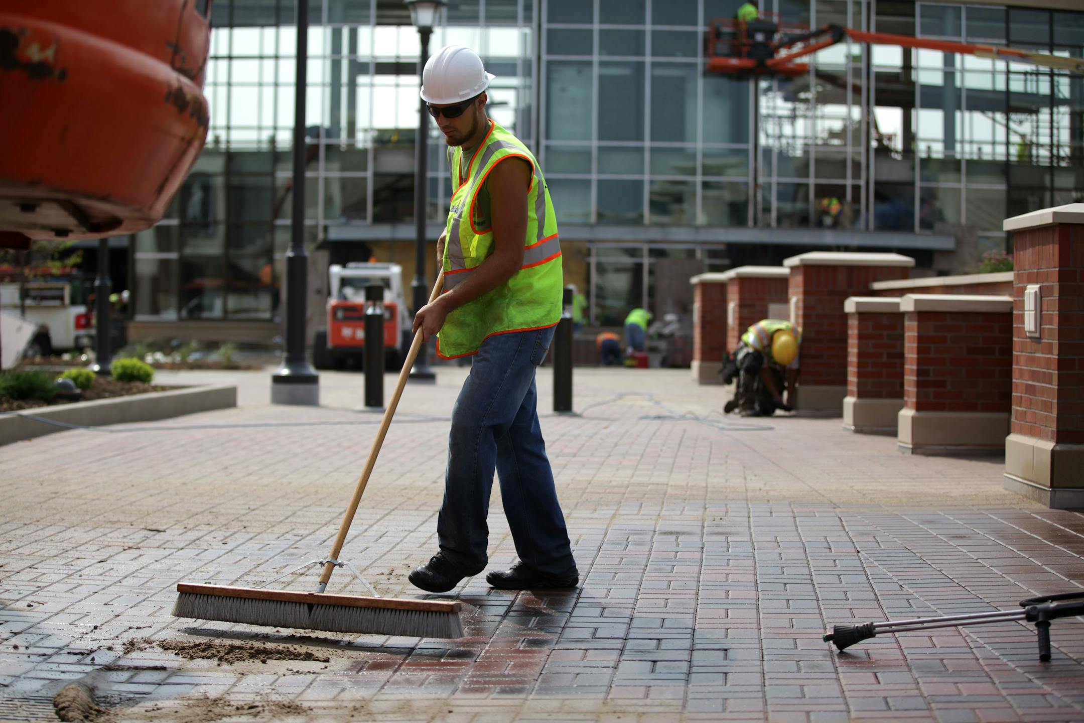 Christian Anderson sweeps the sidewalk after power washing in the Twin Cities Premium Outlets in Eagan on Wednesday morning.