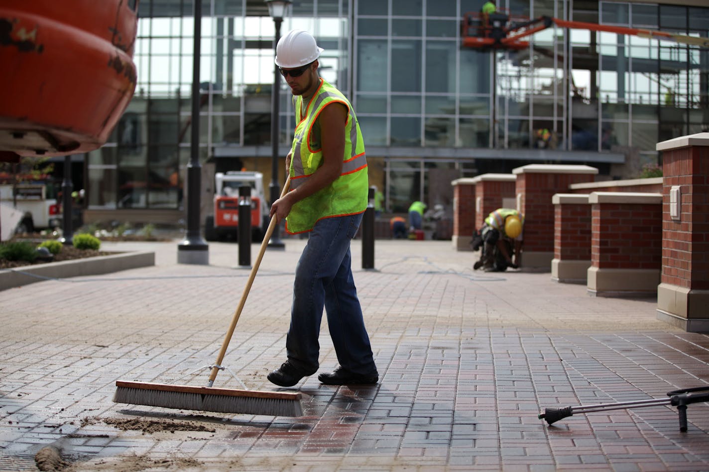 Christian Anderson sweeps the sidewalk after power washing in the Twin Cities Premium Outlets in Eagan on Wednesday morning.