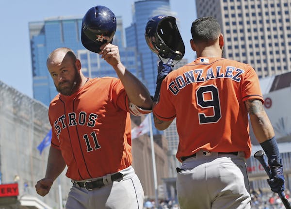 RETRANSMISSION TO CORRECT PITCHERS NAME - Houston Astros' Evan Gattis, left, and Marwin Gonzalez tip helmets after Gattis's solo home run off Minnesot