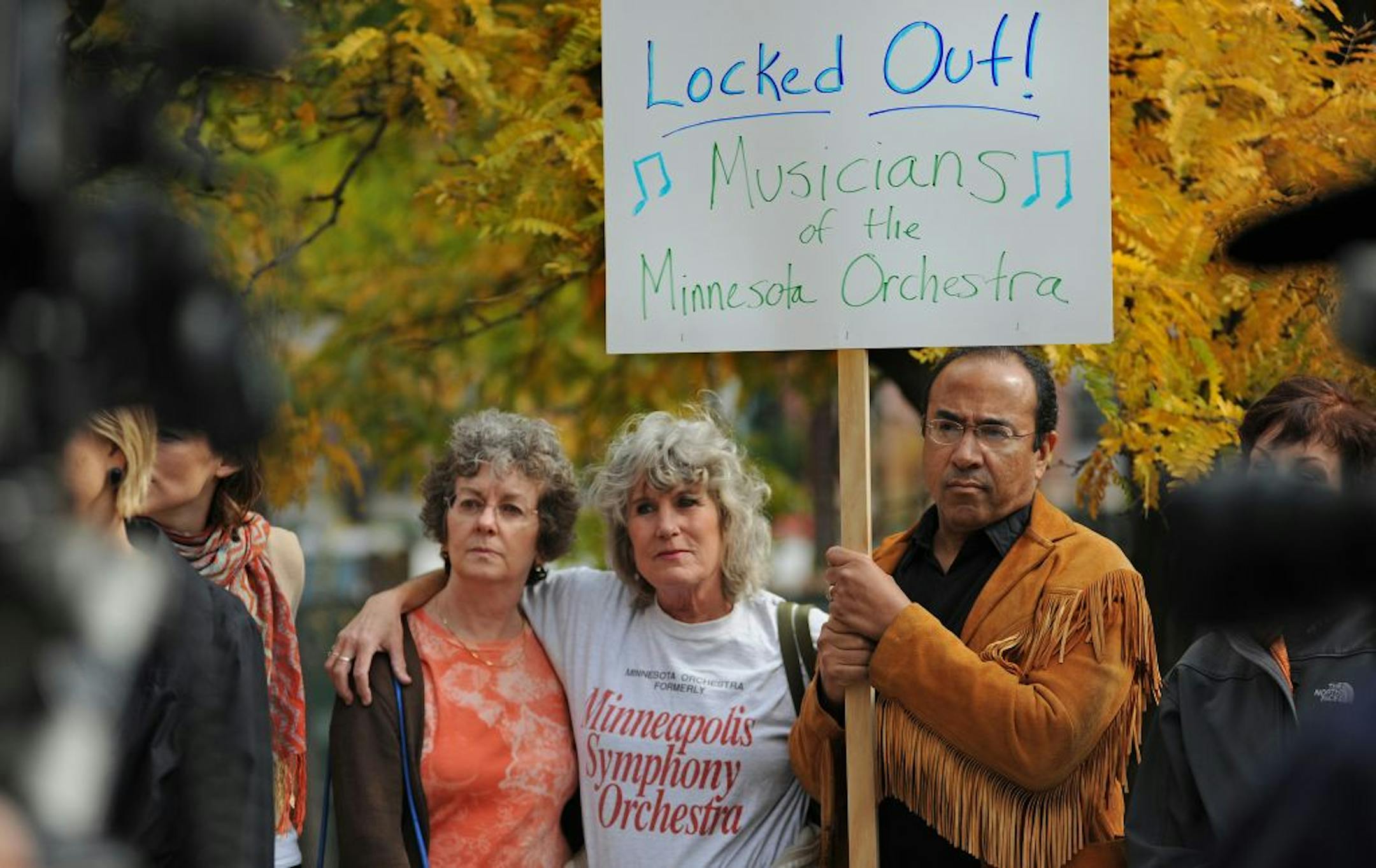 Harpist Kathy Kienzle, left, violinist Laurel Green and trumpet player Manny Laureano were among the dozens of orchestra members who joined a midday rally on Monday outside Orchestra Hall. "Today is a difficult day," said board chairman Jon Campbell.